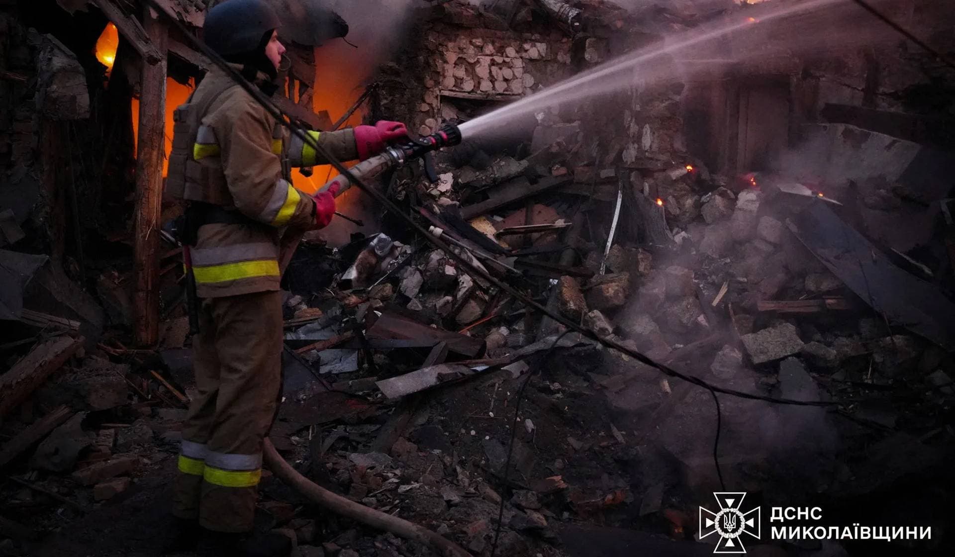 A firefighter works at the site of a residential house hit by a Russian drone strike in Mykolaiv