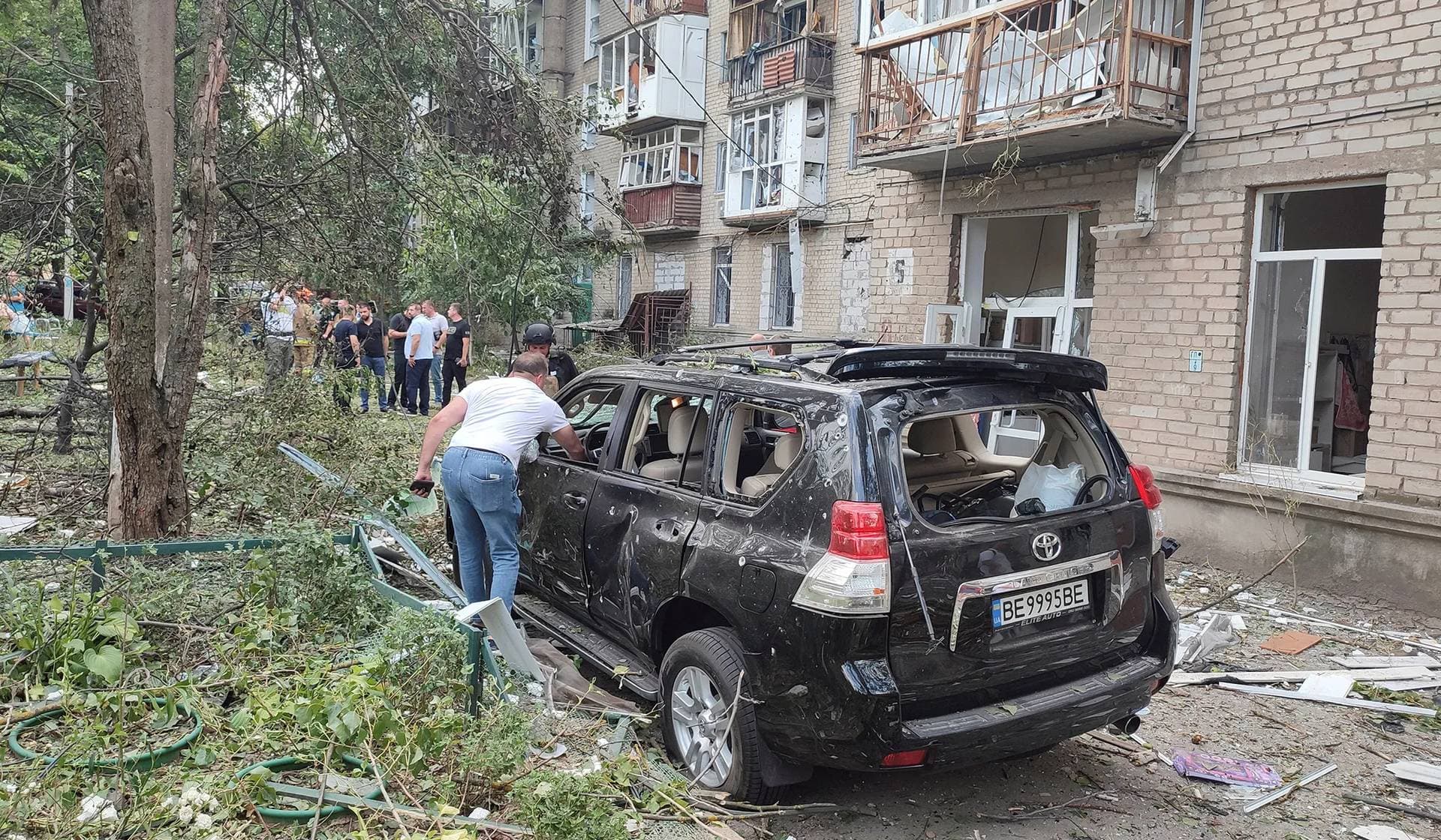 A local resident inspects his destroyed car at an apartment building damaged during a Russian missile strike in Mykolaiv