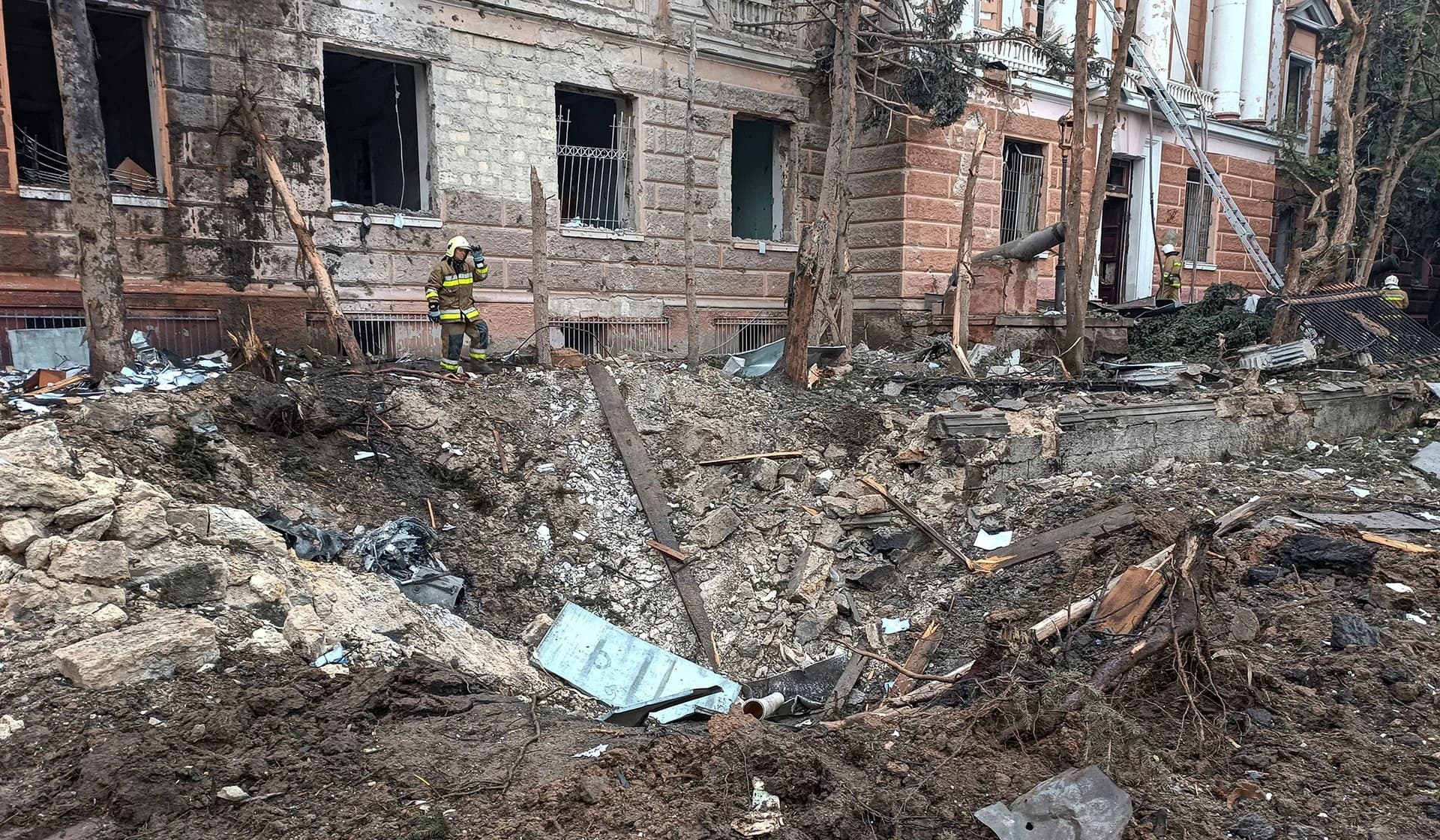 A rescuer stands next to a crater left by a Russian missile strike in Mykolaiv