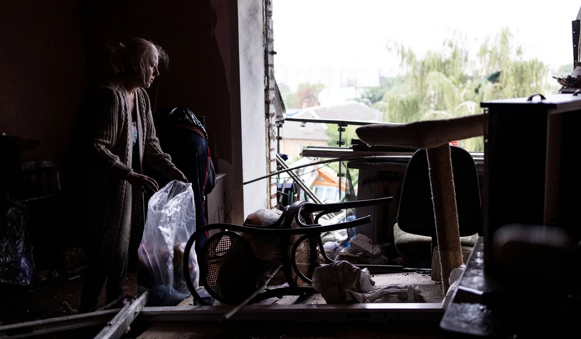 Tamara Movchan collects some belongings from the debris of her apartment at a residential building destroyed by a strike in Mykolaiv