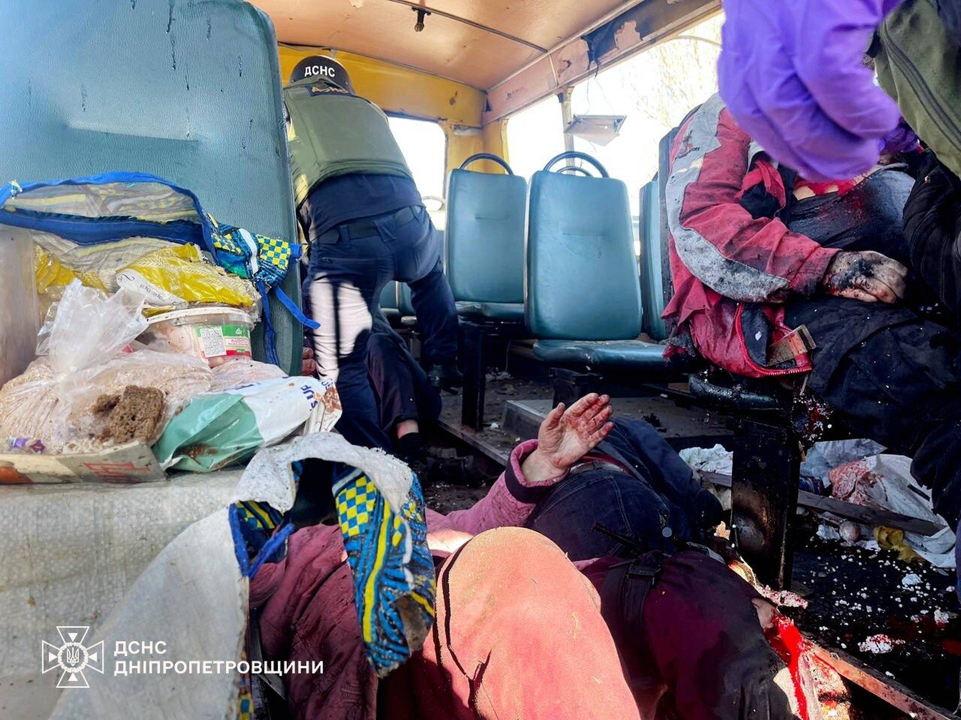rescue workers evacuate injured people from a bus attacked by a Russian drone in Nikopol