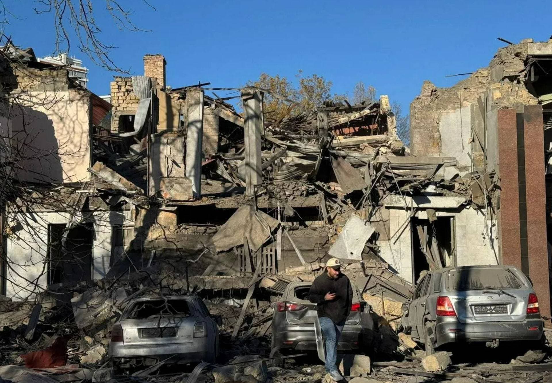 A resident walks next to buildings and cars heavily damaged by a Russian missile strike in Odesa