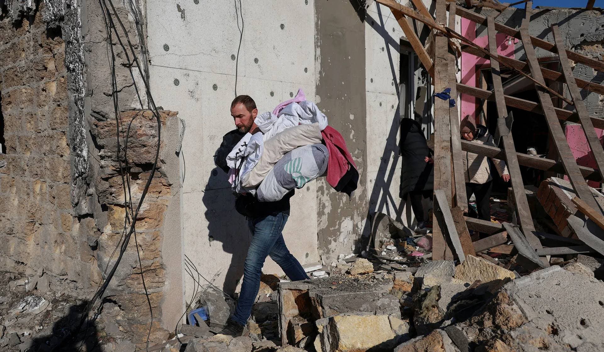 A resident carries outs items from his house heavily damaged by a Russian missile strike in Odesa