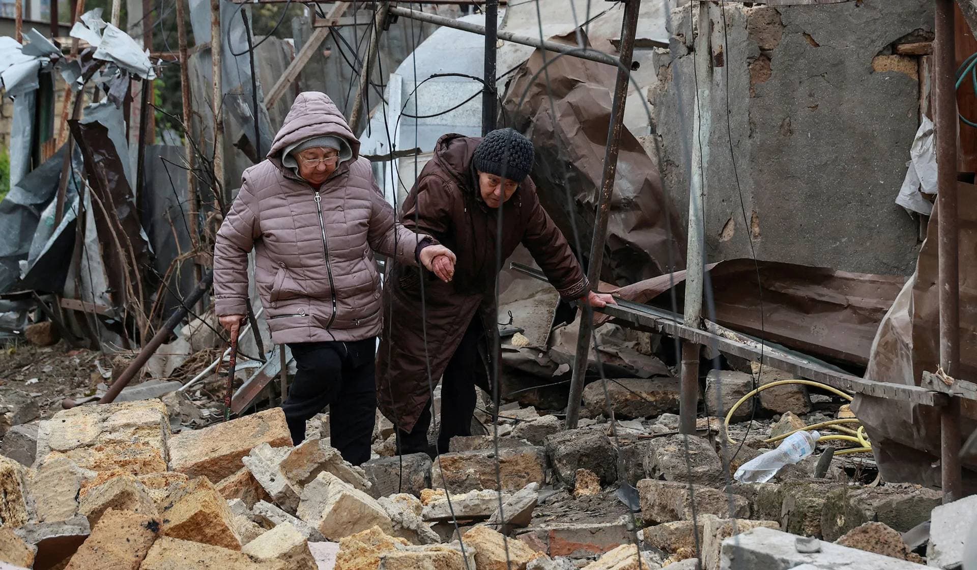 Residents walk through debris at a site of residential area damaged by a Russian drone strike in Odesa
