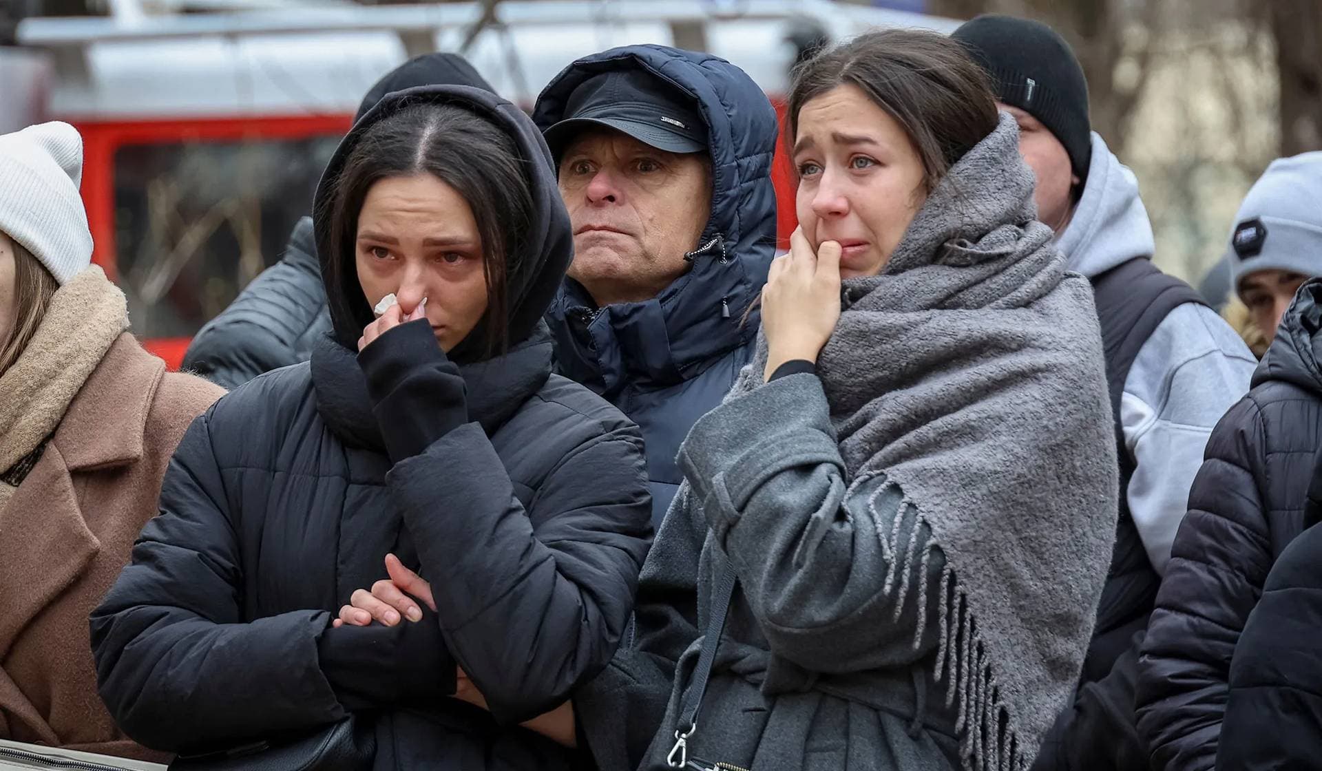 Local residents react at the site of an apartment building heavily damaged by a Russian drone strike in Odesa