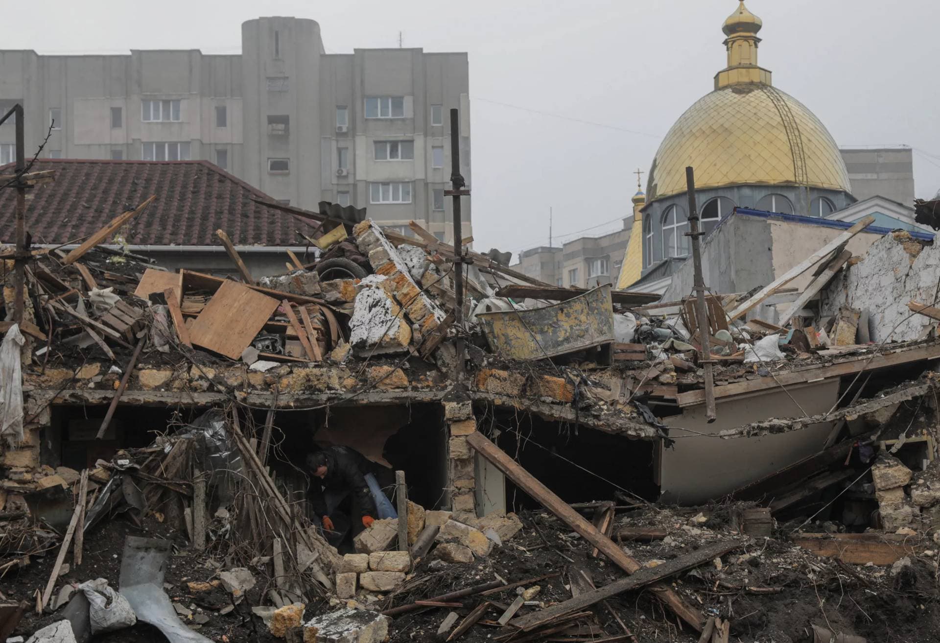 A local resident removes debris at the site where a residential building was destroyed during a Russian missile strike in Odesa