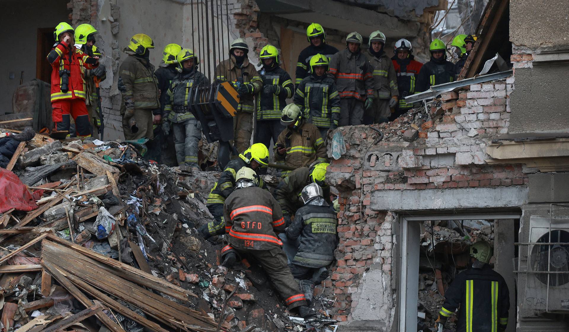 Rescuers place in a bag the body of a person found under debris of an apartment building which was hit during overnight Russian drone strikes in Odesa