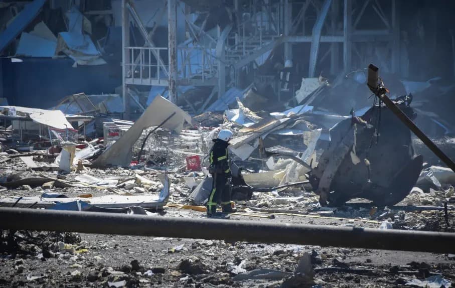 An Ukrainian firefighter works near a destroyed building on the outskirts of Odesa