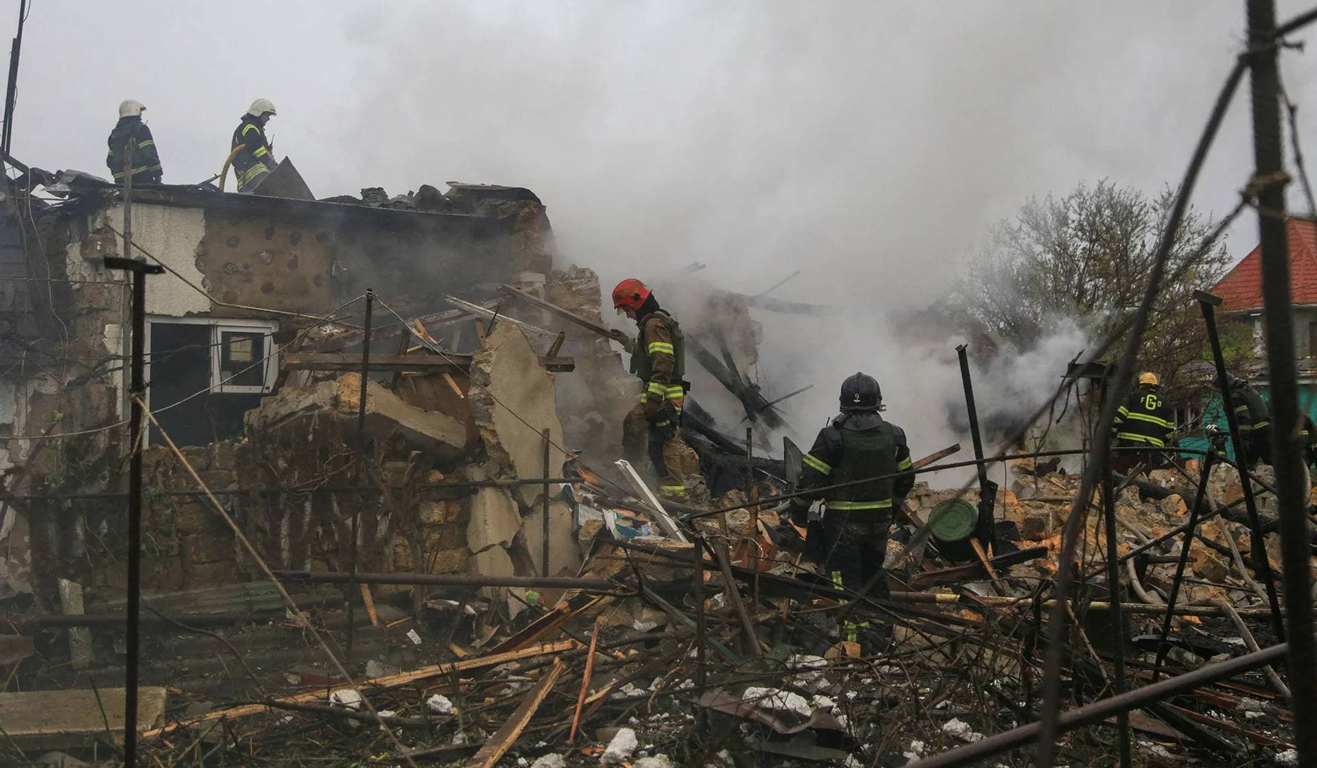 Firefighters work at the site where residential buildings were damaged by a Russian missile strike in Odesa