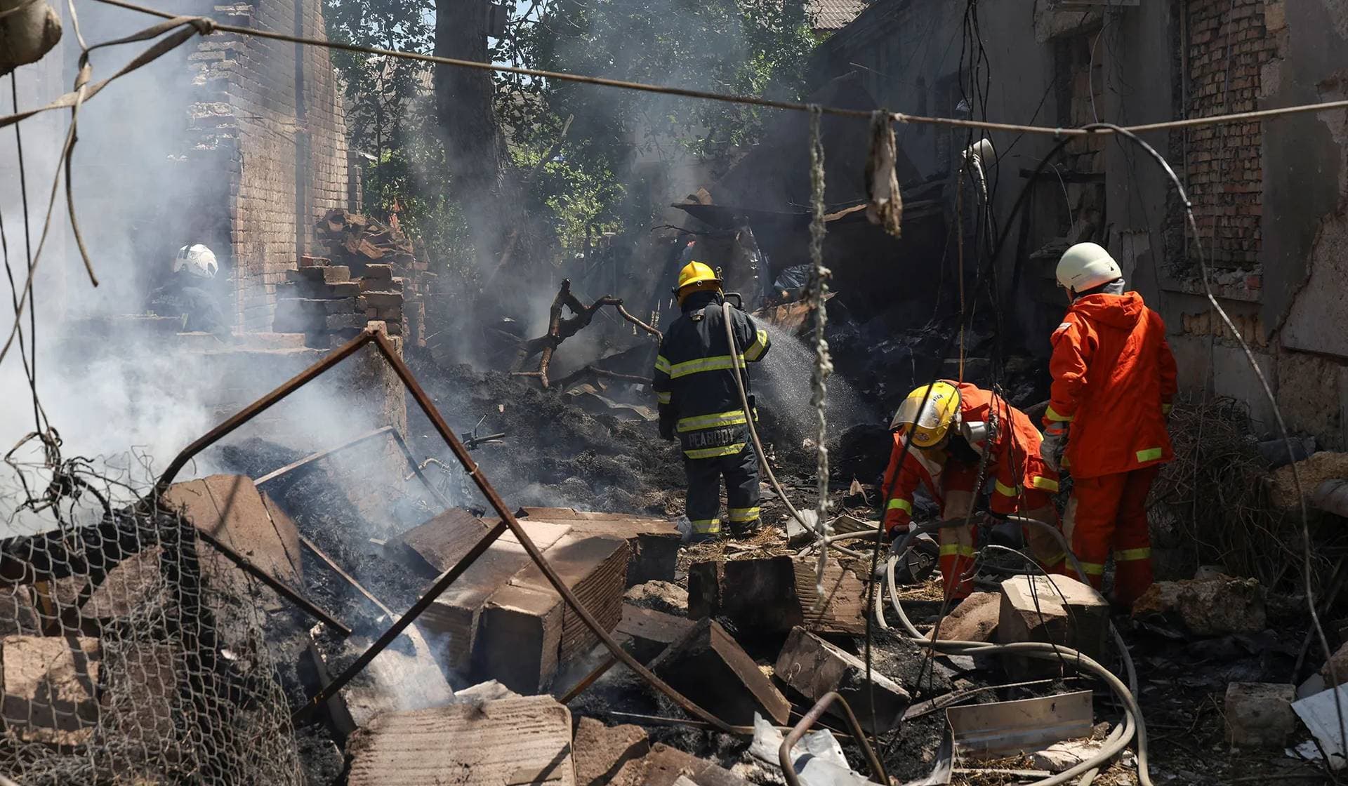 Firefighters work at the site of horse stalls heavily damaged by a Russian drone strike in Odesa