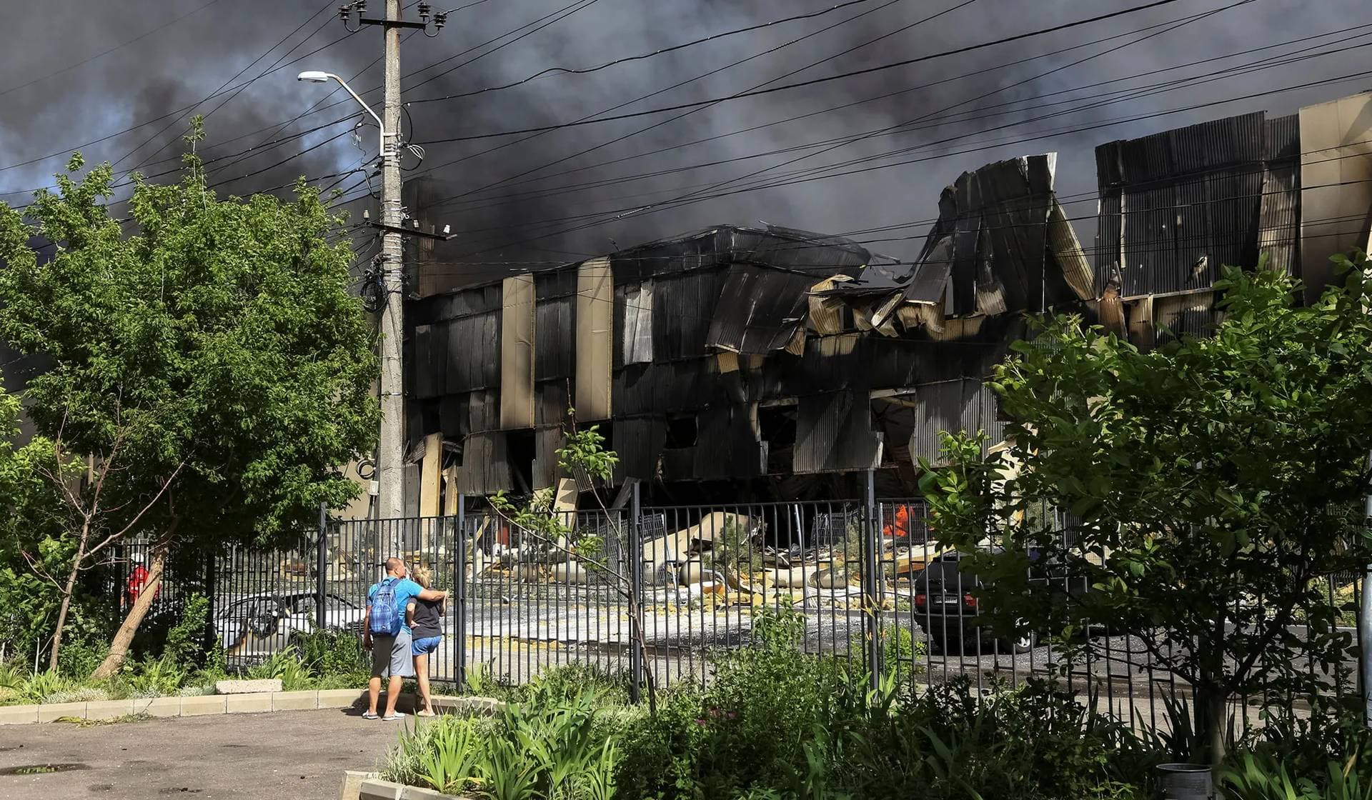 Local residents stand at a site of a Russian missile strike in Odesa