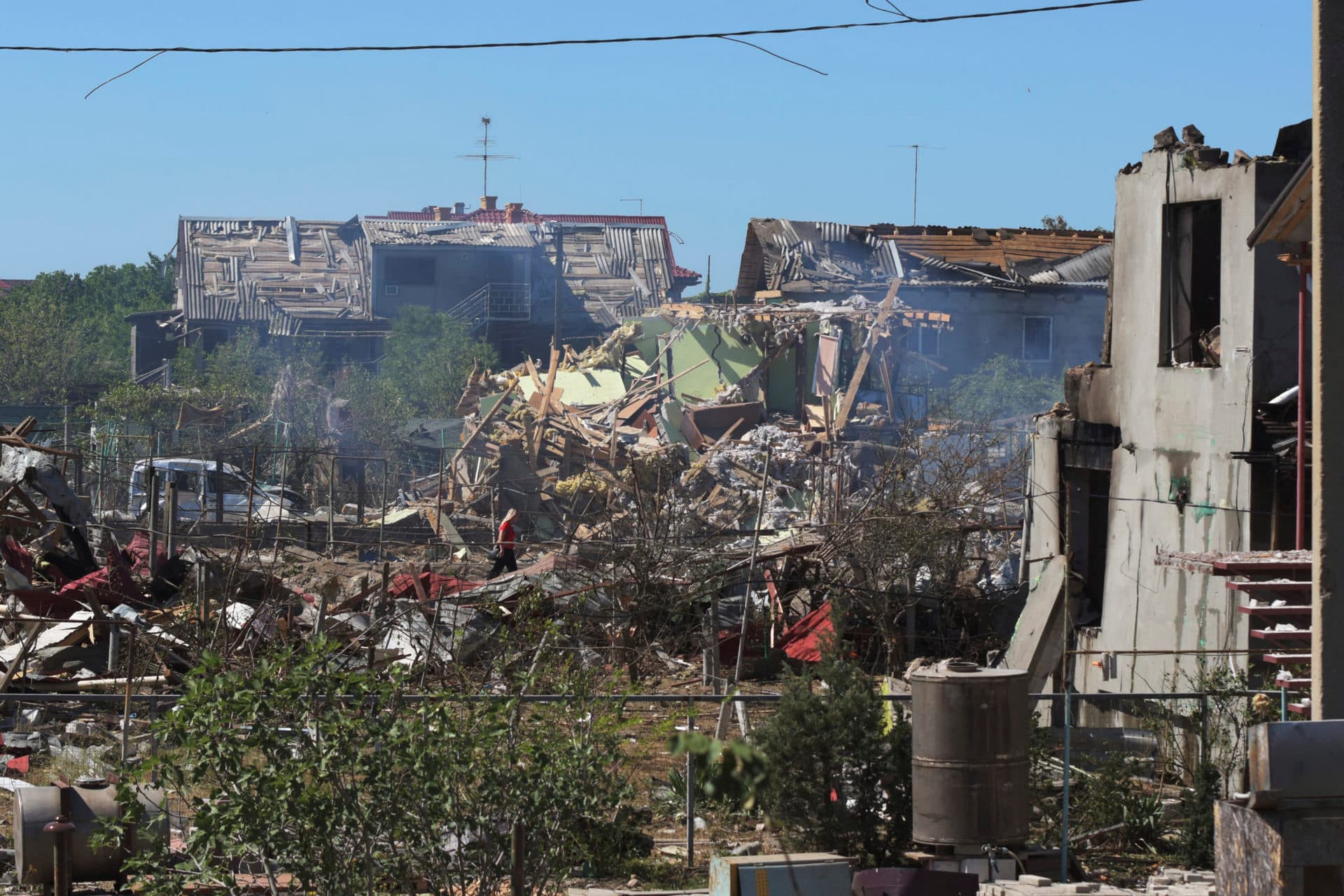 A woman walks among apartment buildings destroyed by Russian shelling on the outskirts of Odesa