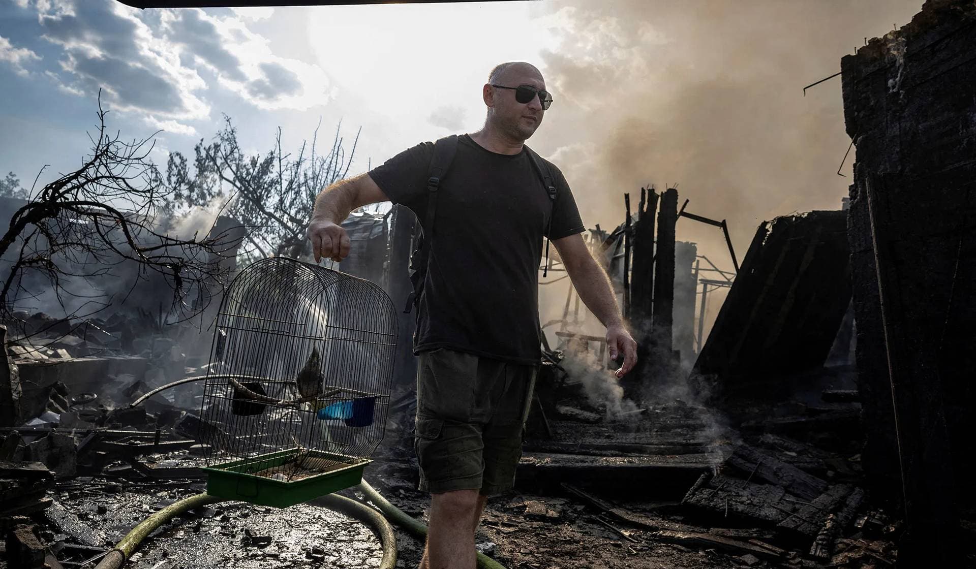 A local man rescues a pet bird from a house that was destroyed after a Russian strike on a residential area in Pokrovsk