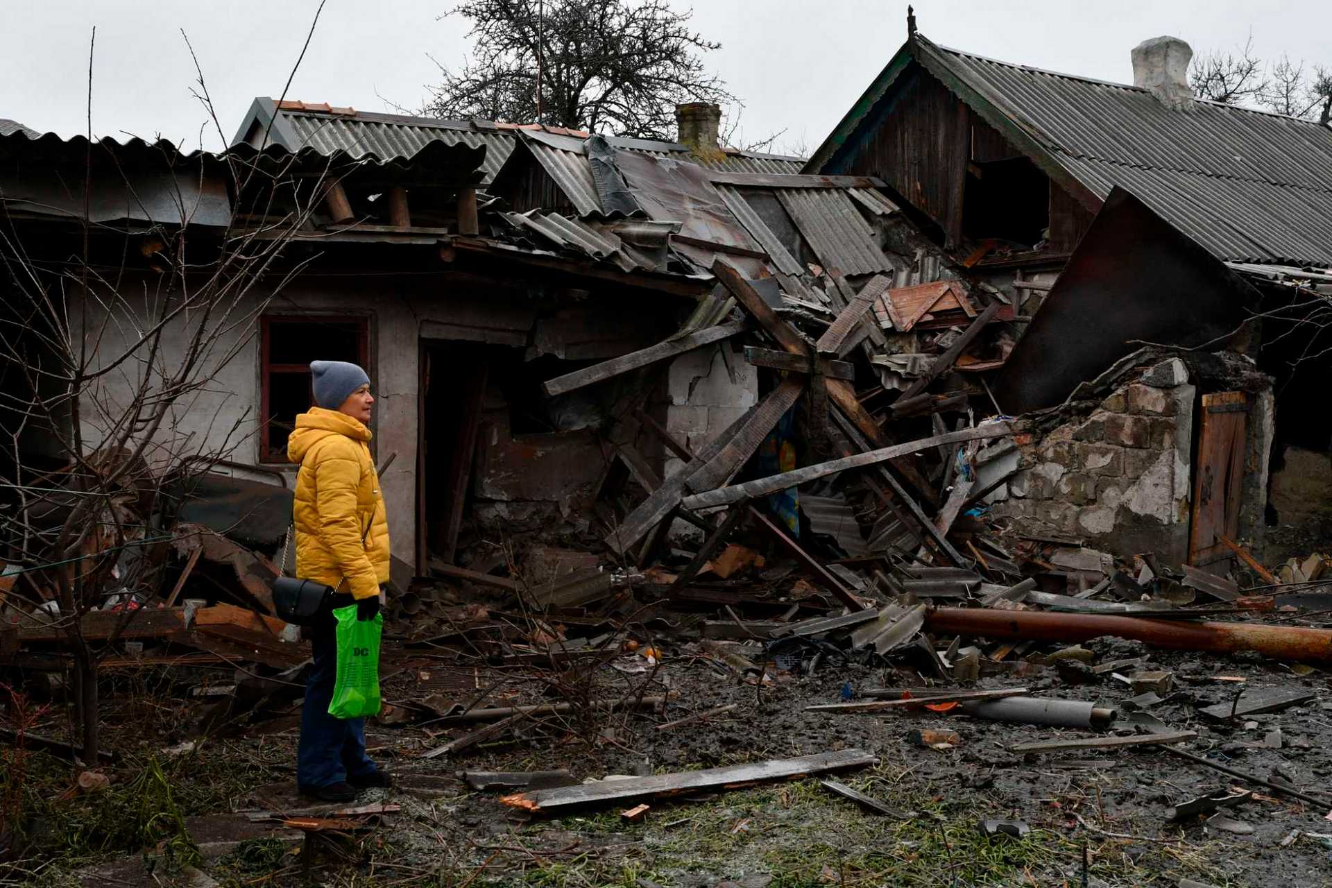 A woman stands near debris of her house following Wednesday's Russian shelling, in Kurakhove
