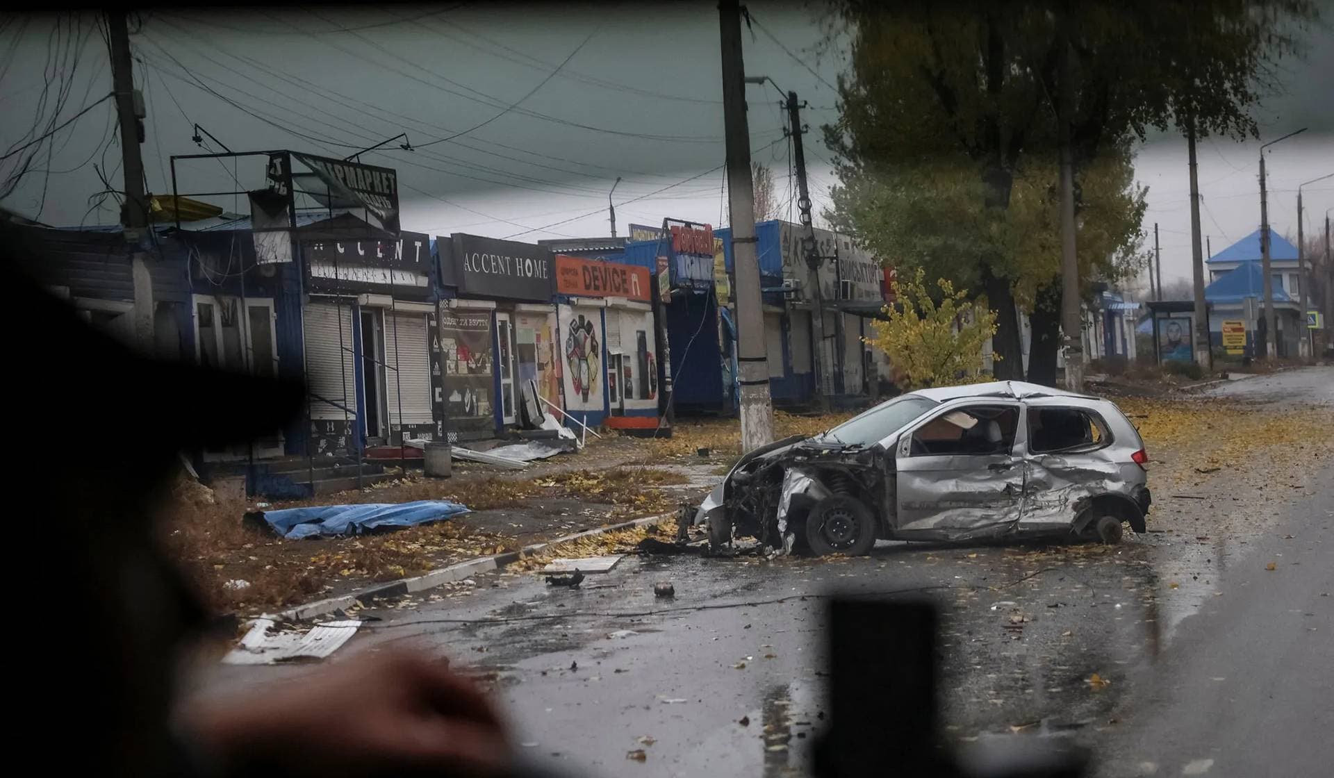 A car destroyed by a Russian military strike lies on a road in the frontline town of Dobropillia