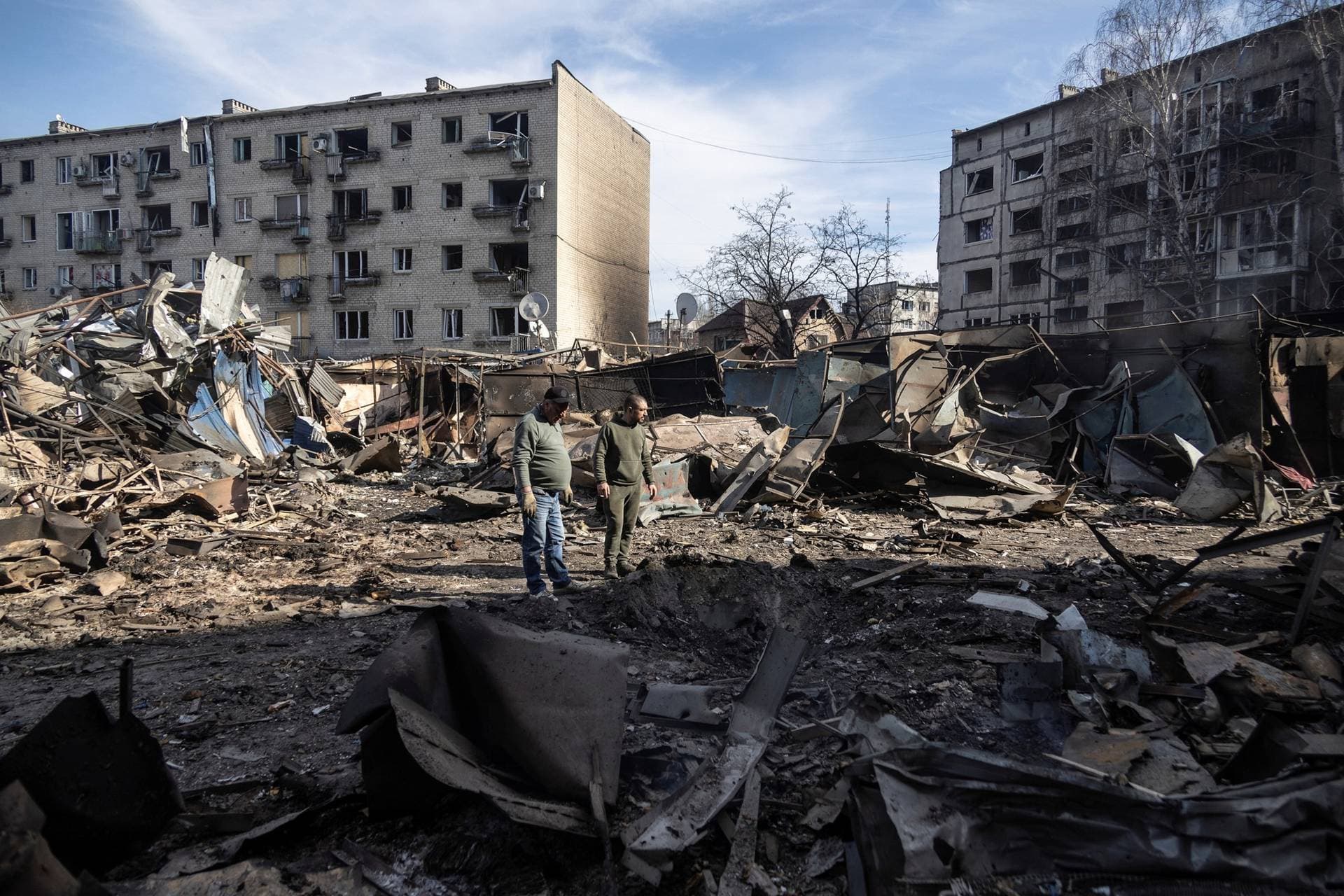 Residents stand at the site of apartment buildings hit by a Russian missile strike in Dobropillia