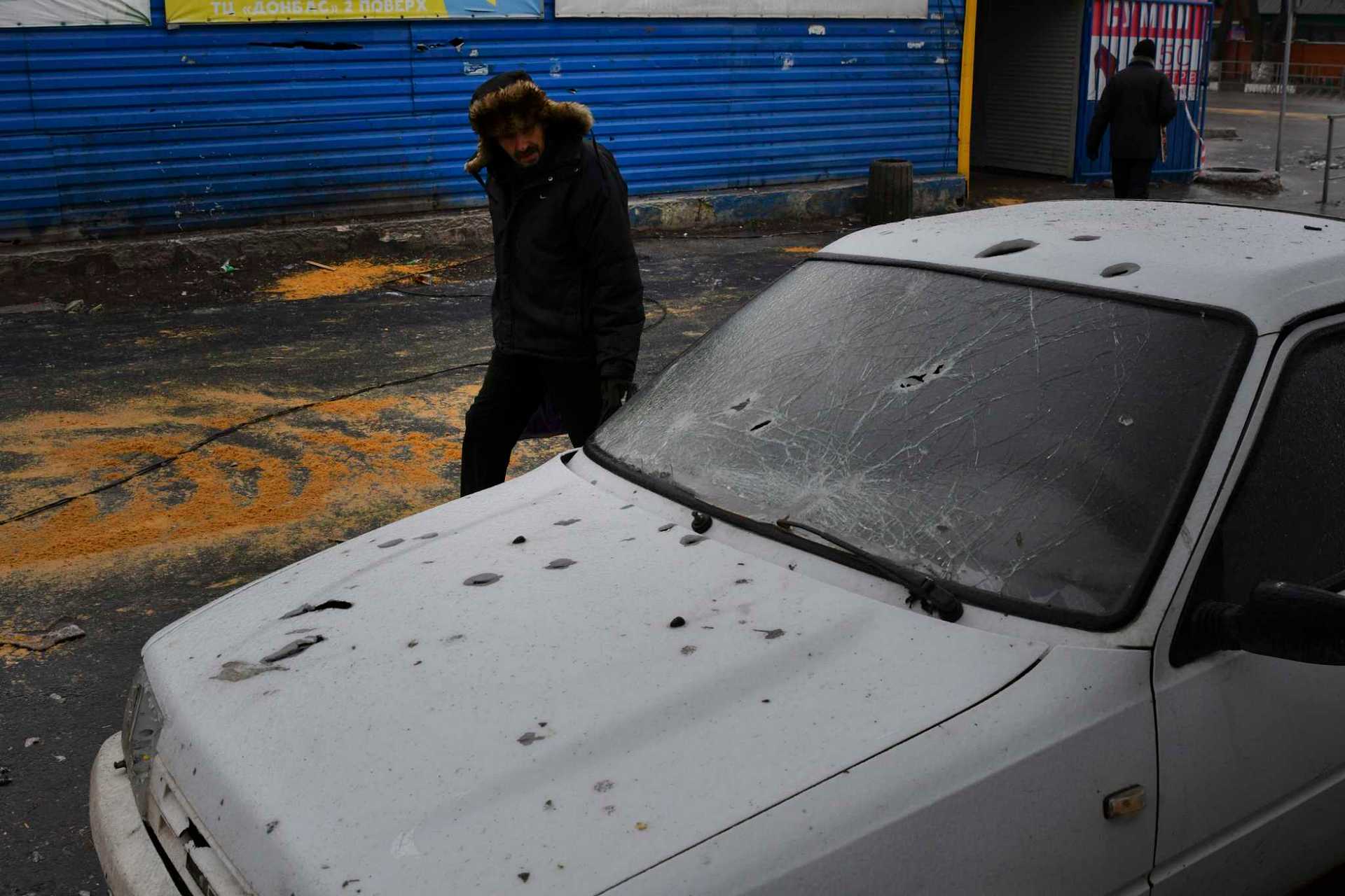 A man passes by a car damaged following Wednesday's Russian shelling, in Kurakhove