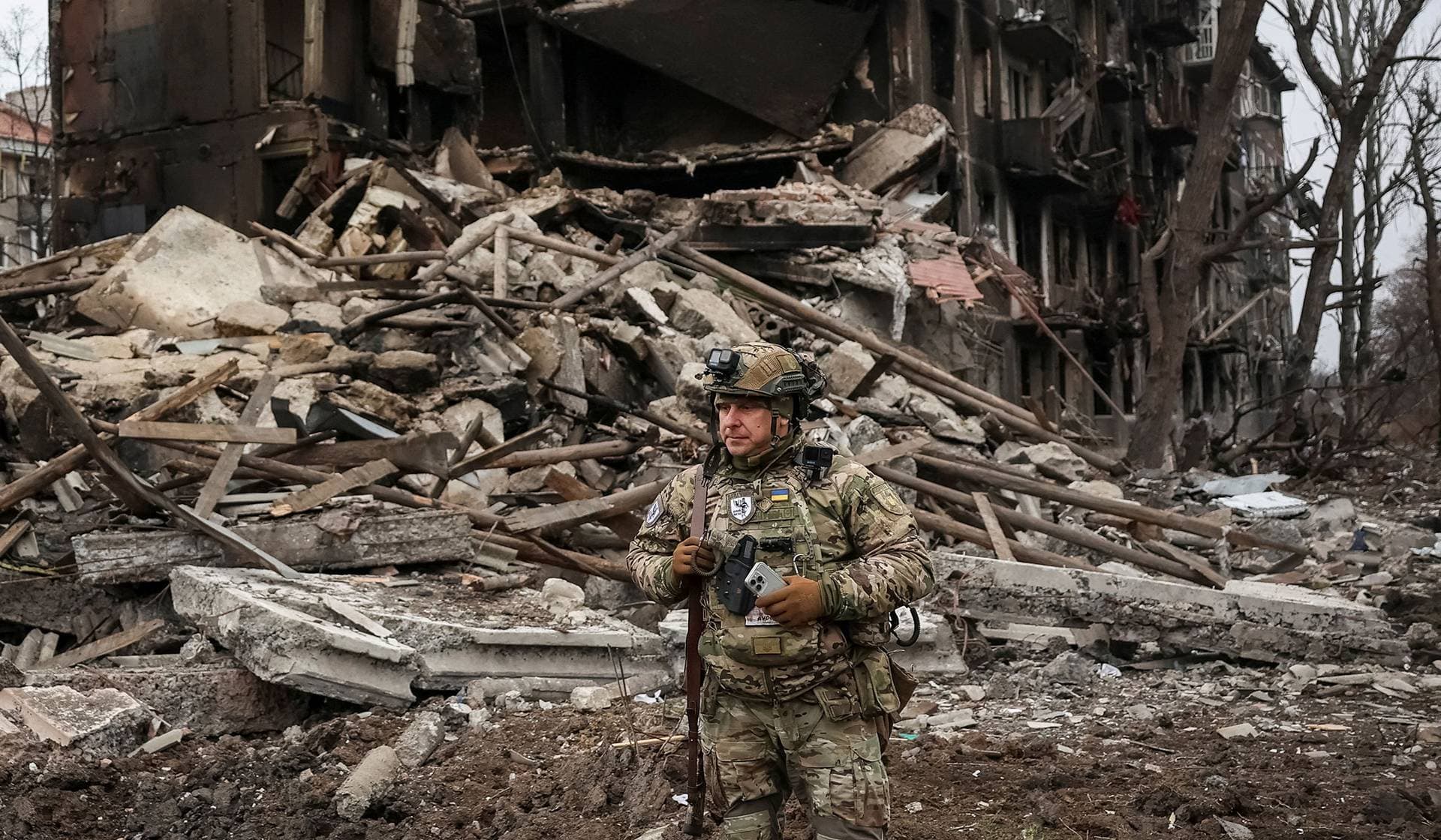 A member of the White Angel unit of Ukrainian police officers, who evacuate people from the frontline towns and villages, checks an area for residents in the frontline town of Dobropillia