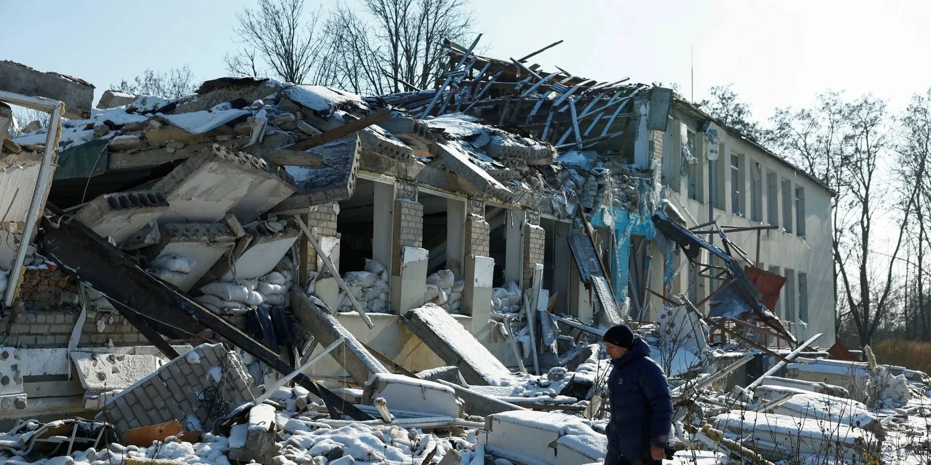 Yurii Bilyk walks next to its building destroyed by a recent Russian air strike in the village of Novopavlivka