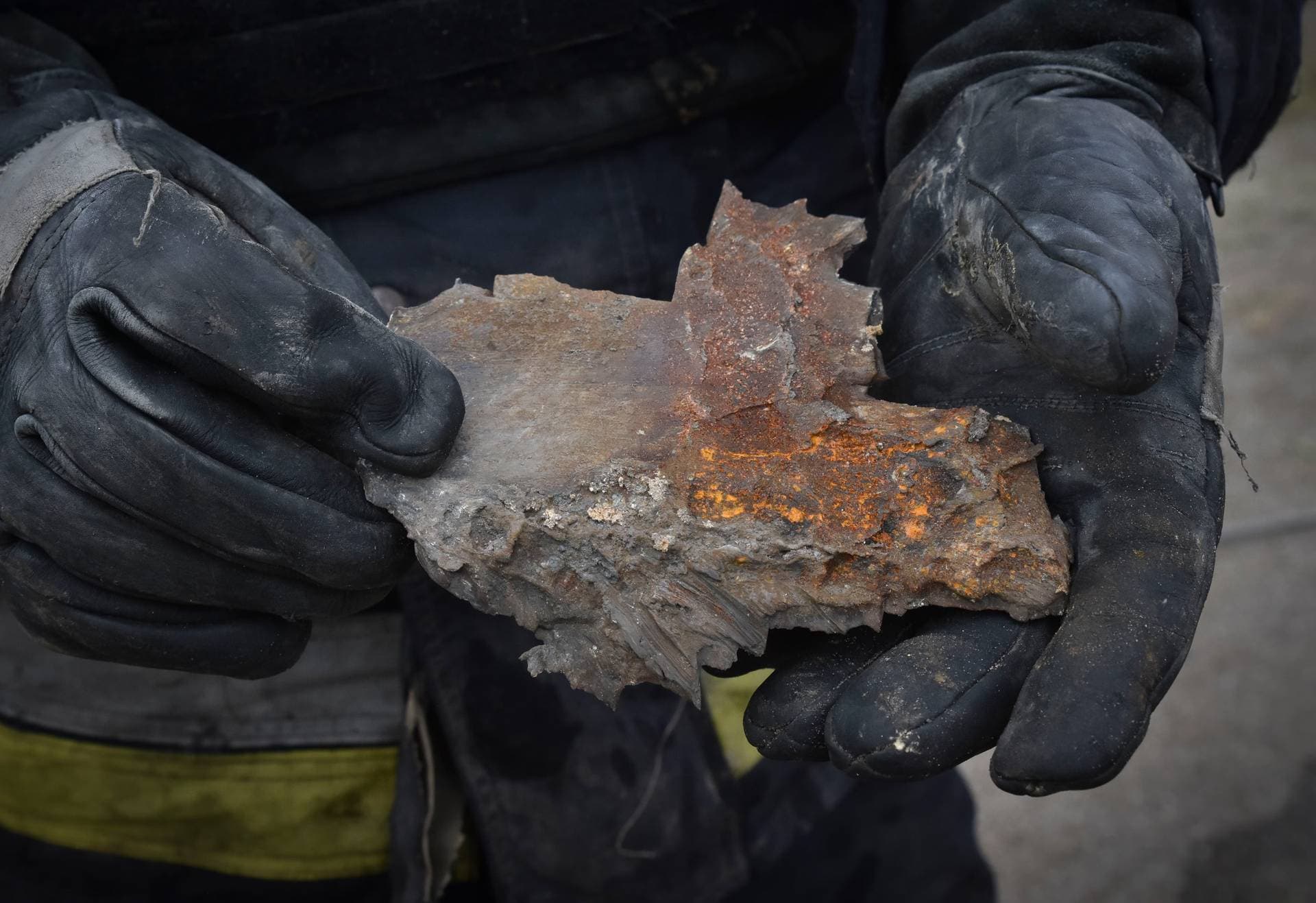 A Ukrainian State Emergency Service firefighter holds a bomb fragment after a Russian air raid hit apartment buildings in Orihiv