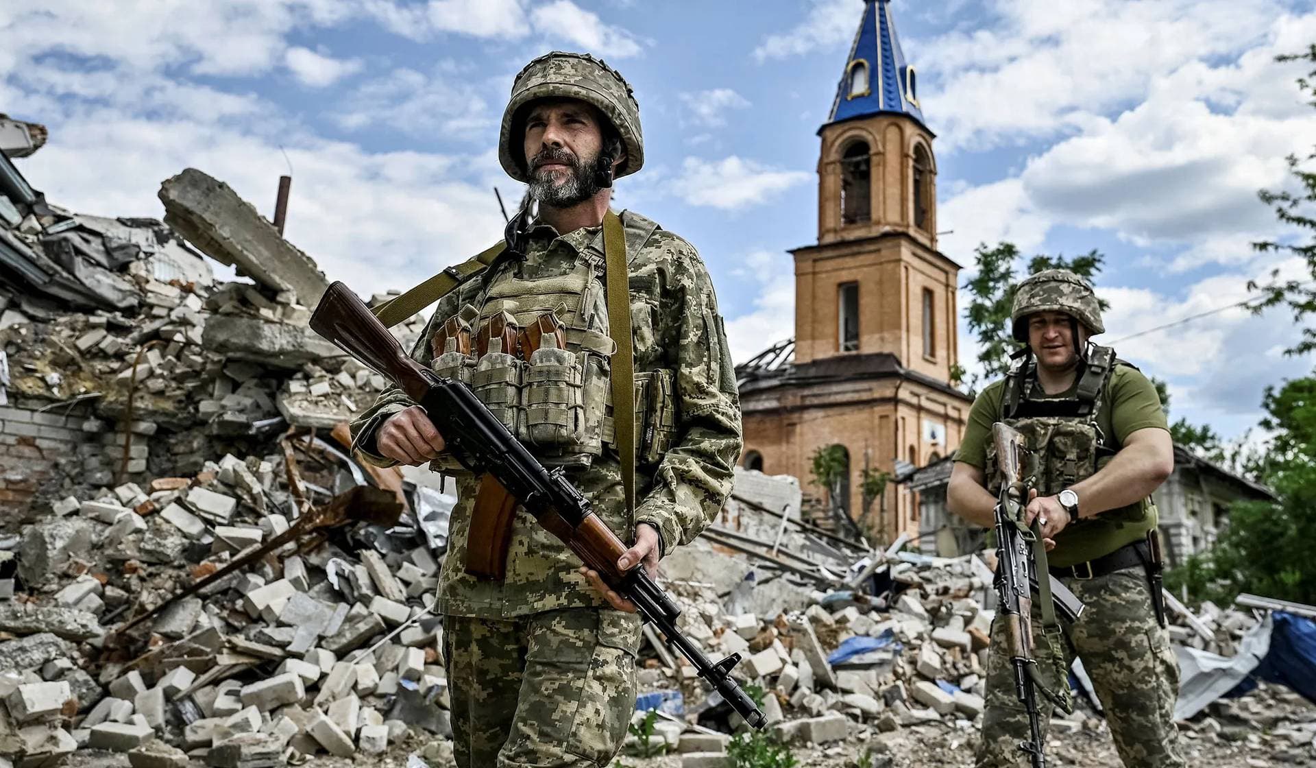 Ukrainian servicemen patrol an area heavily damaged by Russian military strikes in Orikhiv