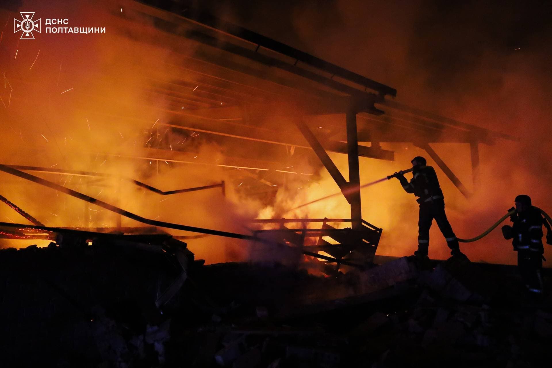 Firefighters work at the site of a Russian drone strike in Poltava Region