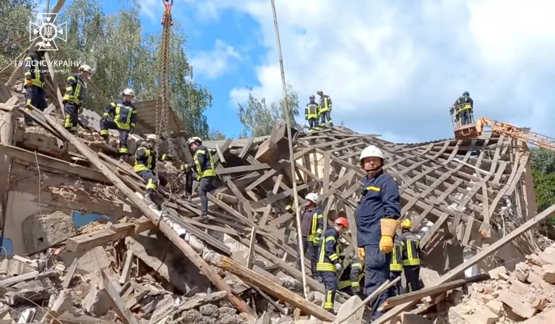Rescuers work at the site of a Russian drone strike in Romny