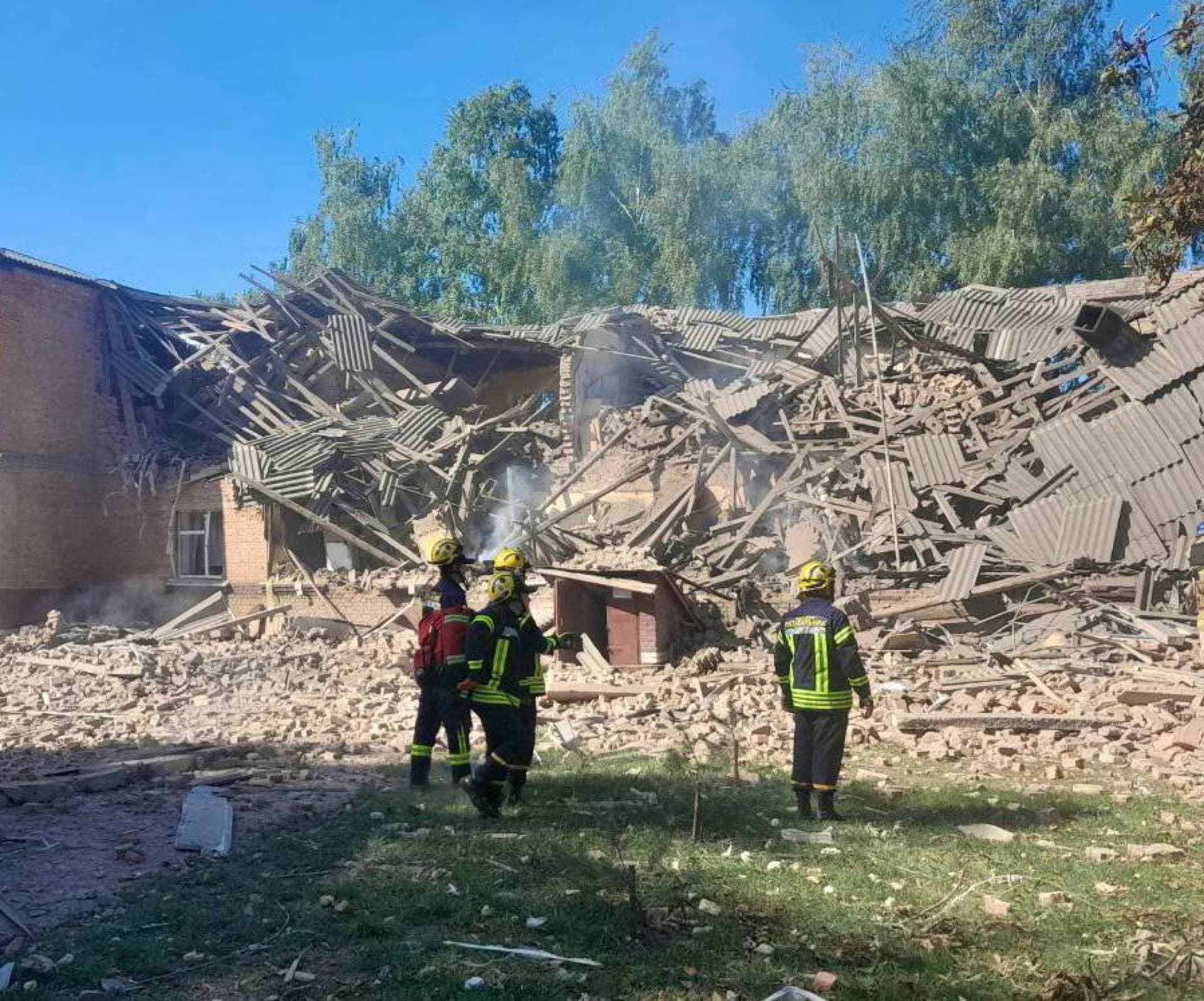 Rescuers work at the site of a Russian drone strike in Romny