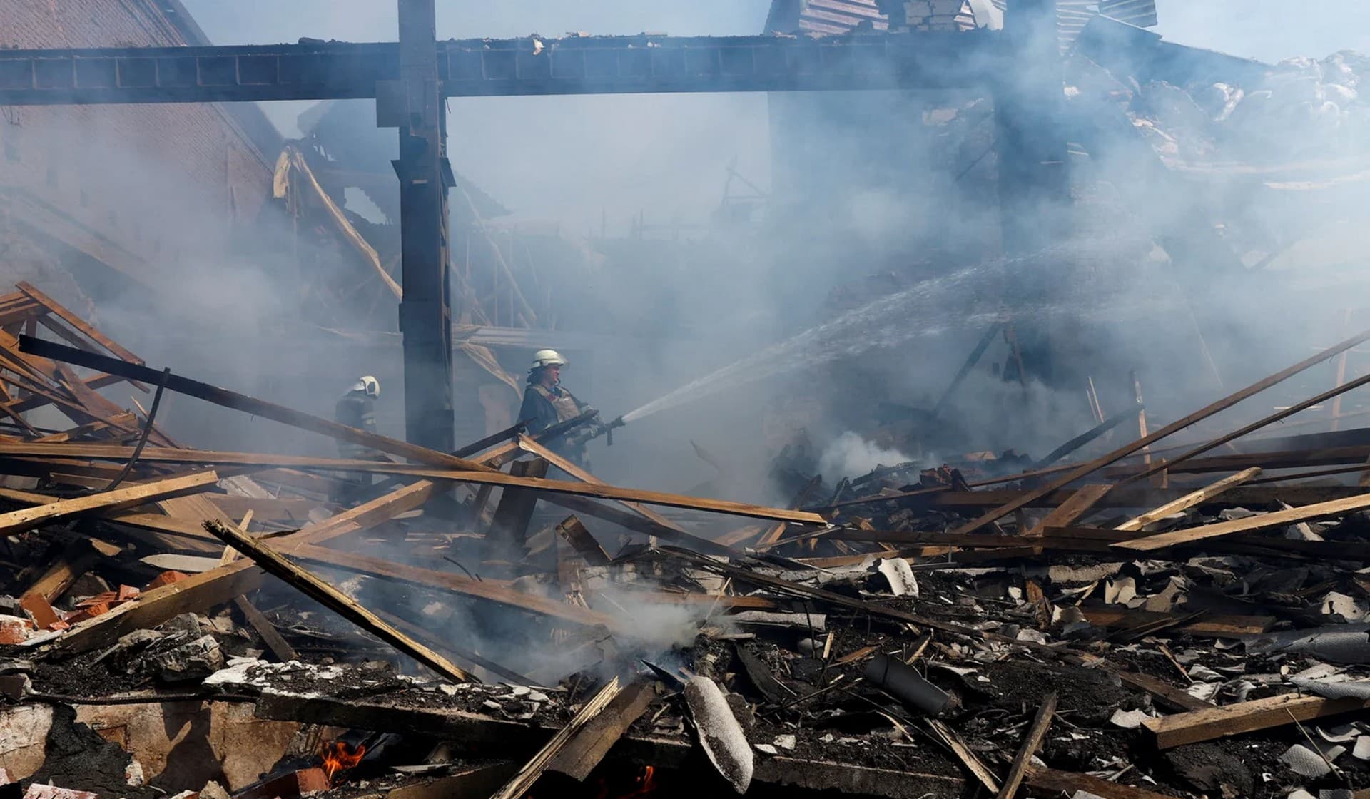 A Ukrainian firefighter takes rest in a factory destroyed by a Russian strike in the city of Slovyansk