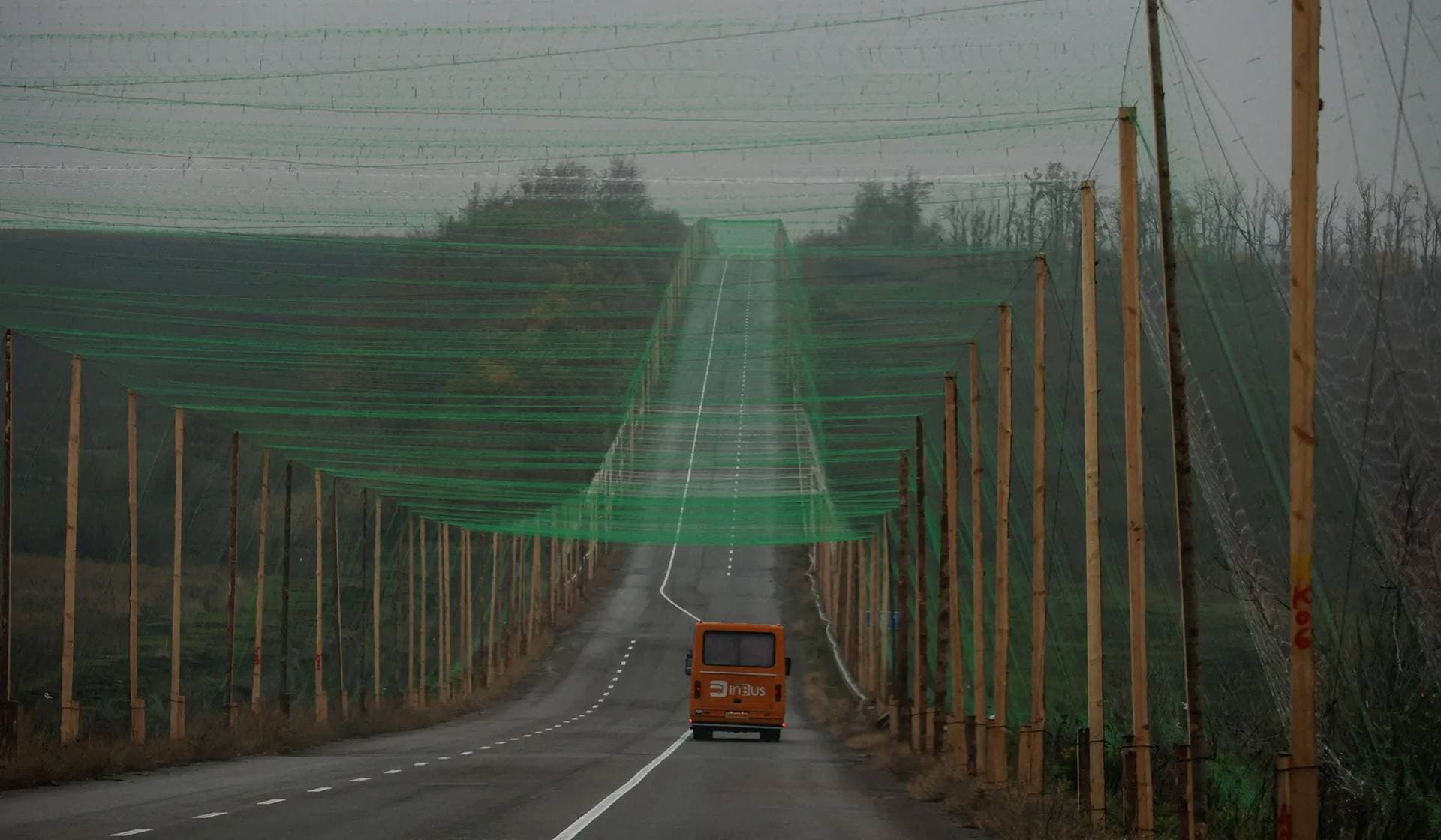 A car drives along a road covered with an anti-drone net near the town of Sloviansk
