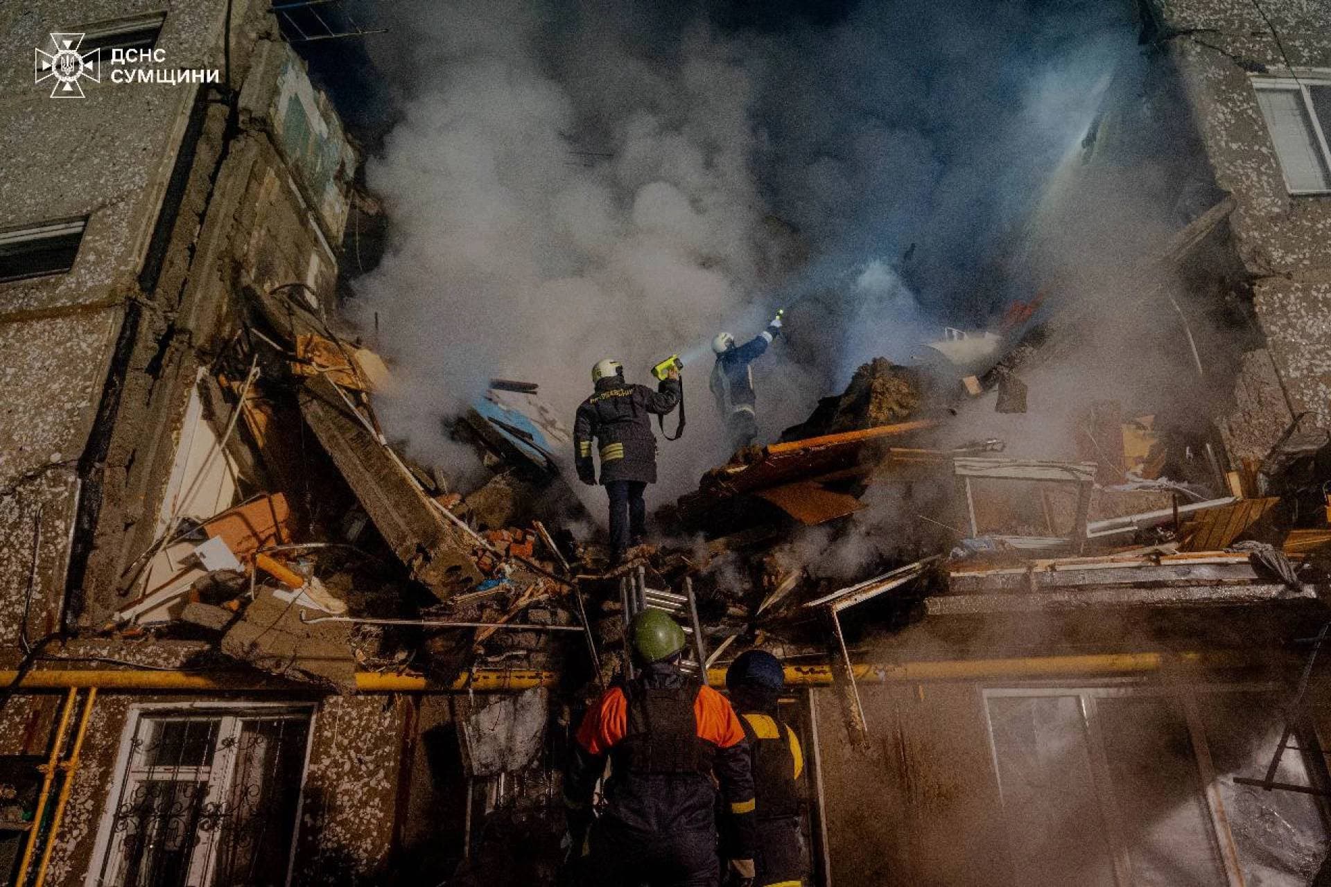 Rescuers work at a site of an apartment building heavily damaged by a Russian drone strike in Sumy