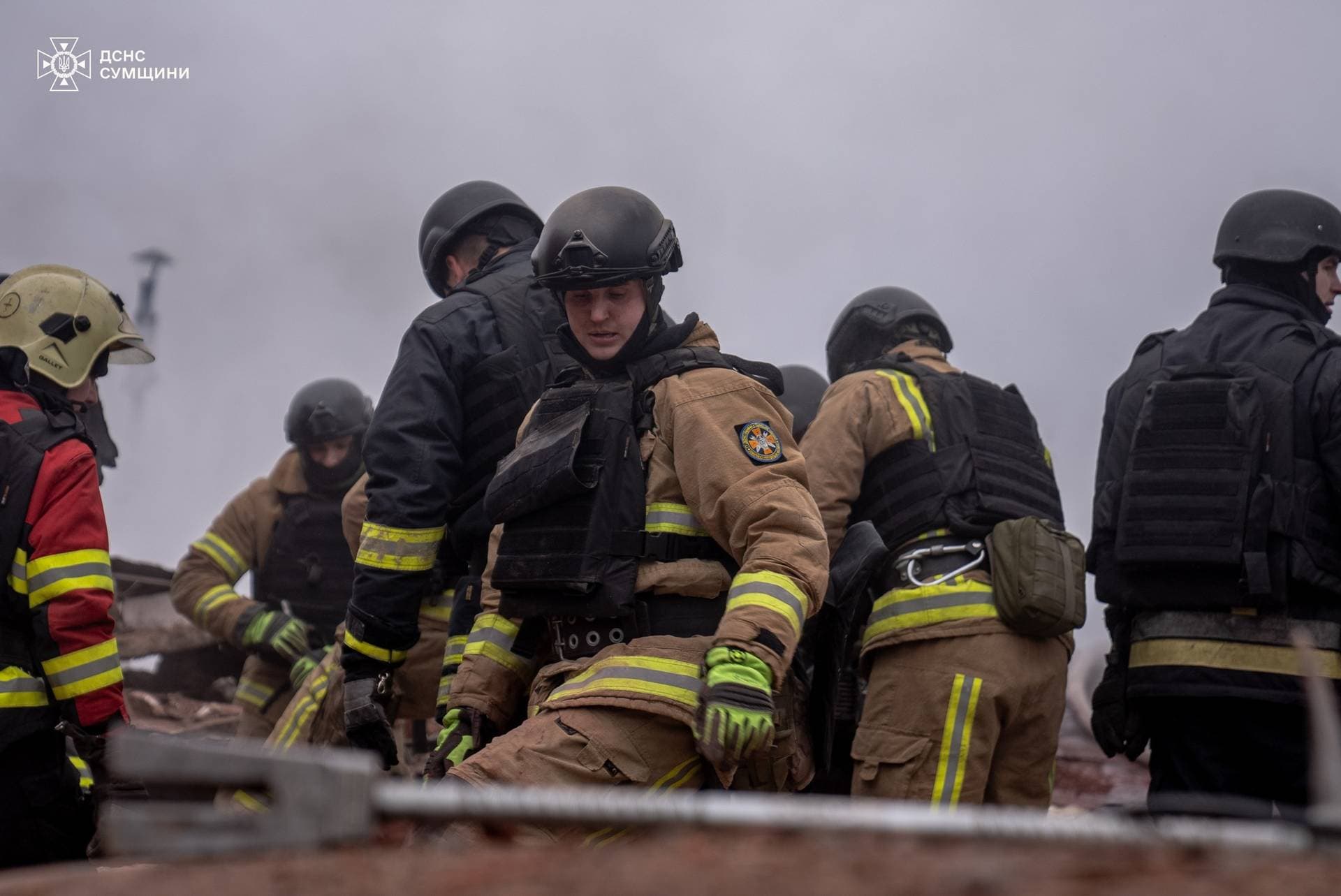 Rescuers removes debris as they search for people at the site of a Russian military strike in Sumy