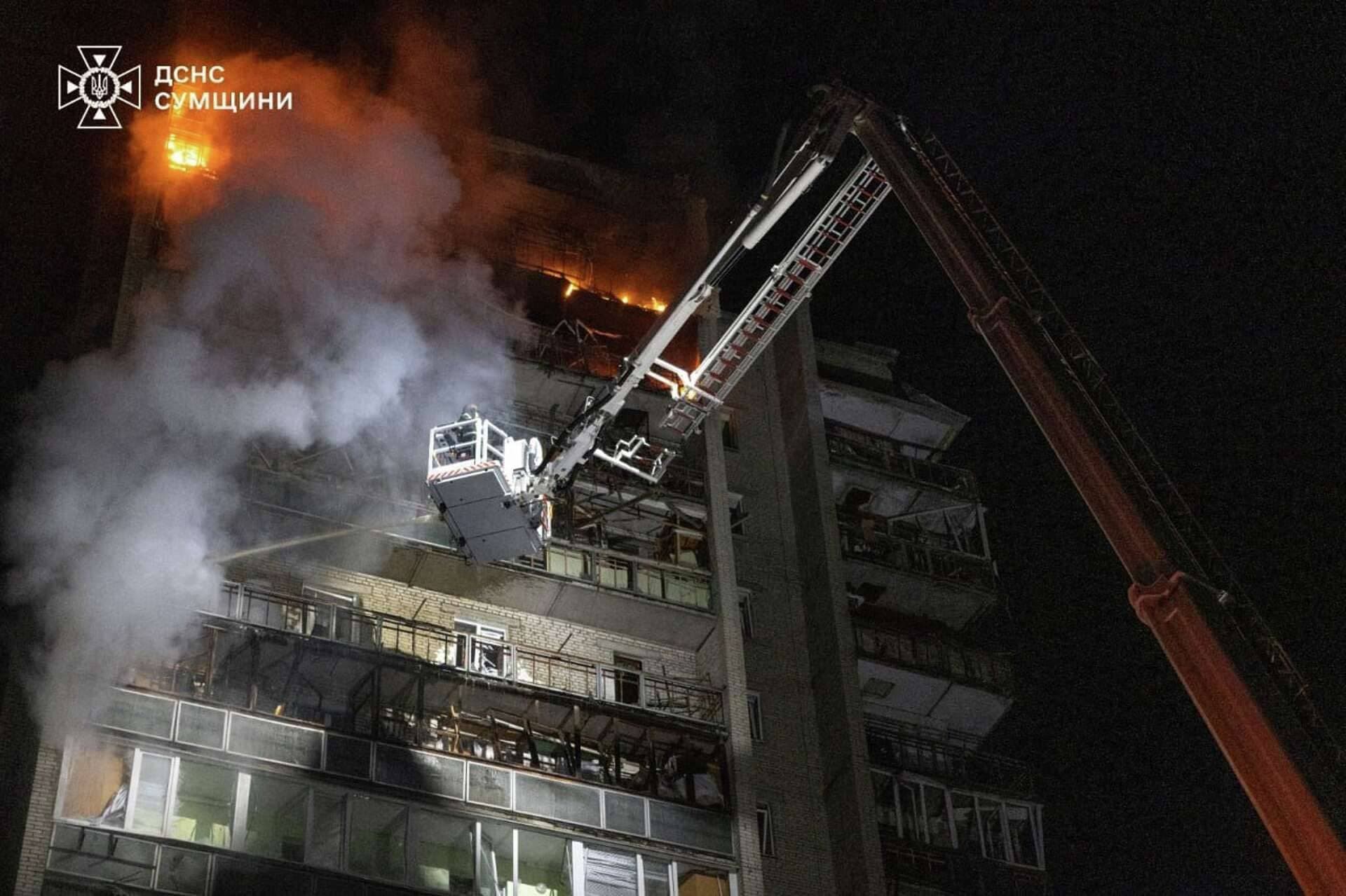 Firefighters work to extinguish a fire at an apartment building hit by a Russian drone strike in Sumy