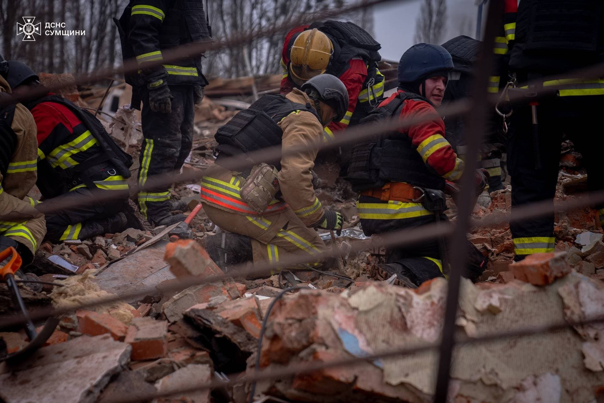 Rescuers removes debris as they search for people at the site of a Russian military strike in Sumy