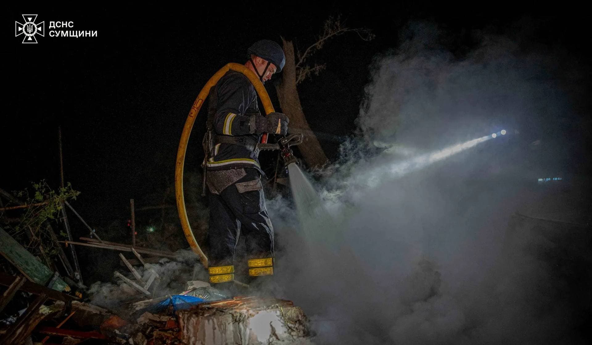 A firefighter works at a site of residential buildings heavily damaged by a Russian air strike in Sumy