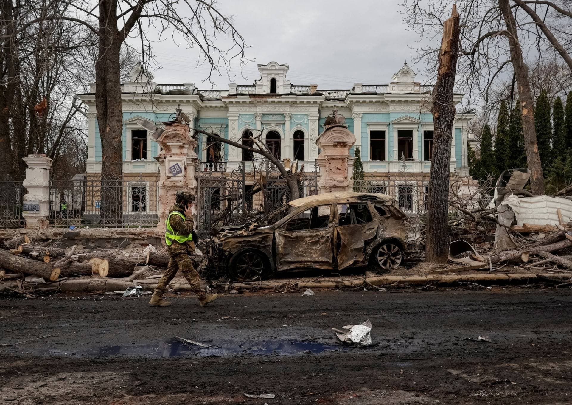 A Ukrainian serviceman walks at the site of a Russian missile strike in Sumy