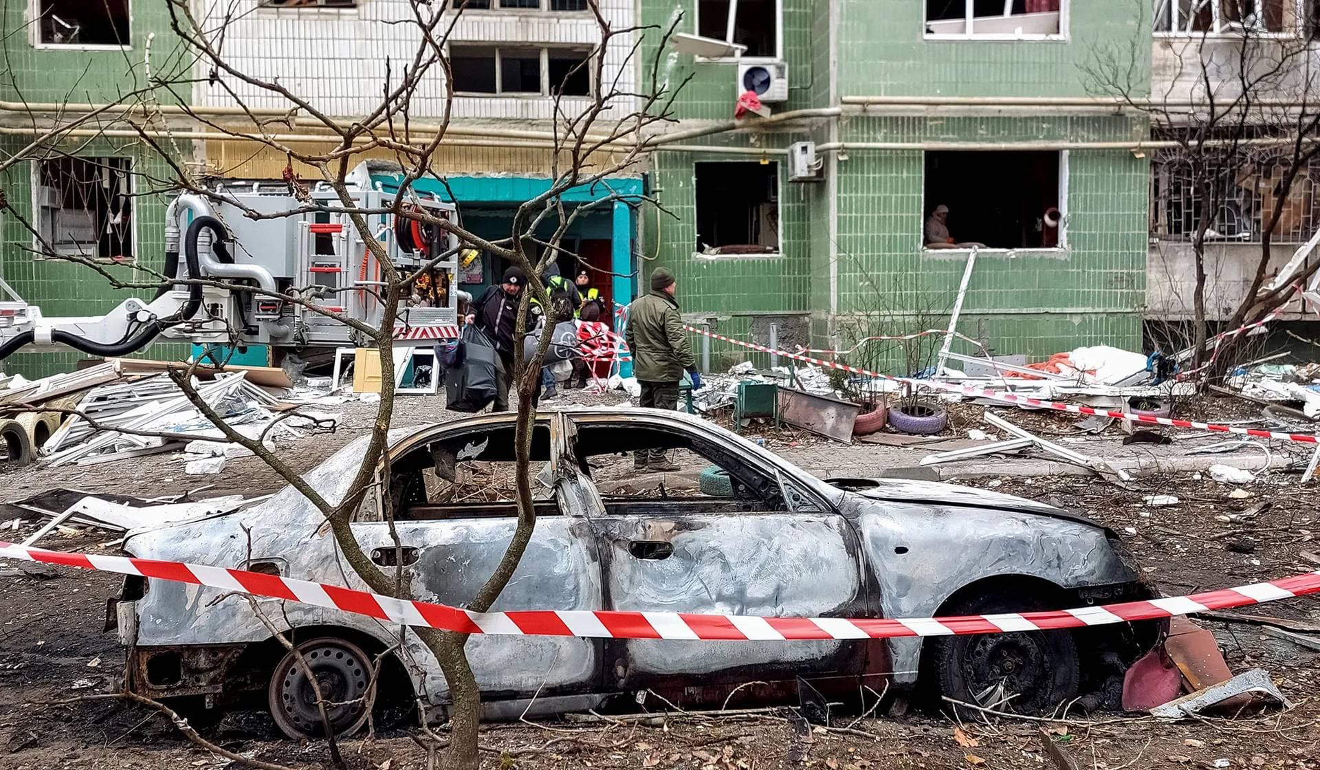 A destroyed car in front of a residential building damaged by a Russian missile strike in Sumy