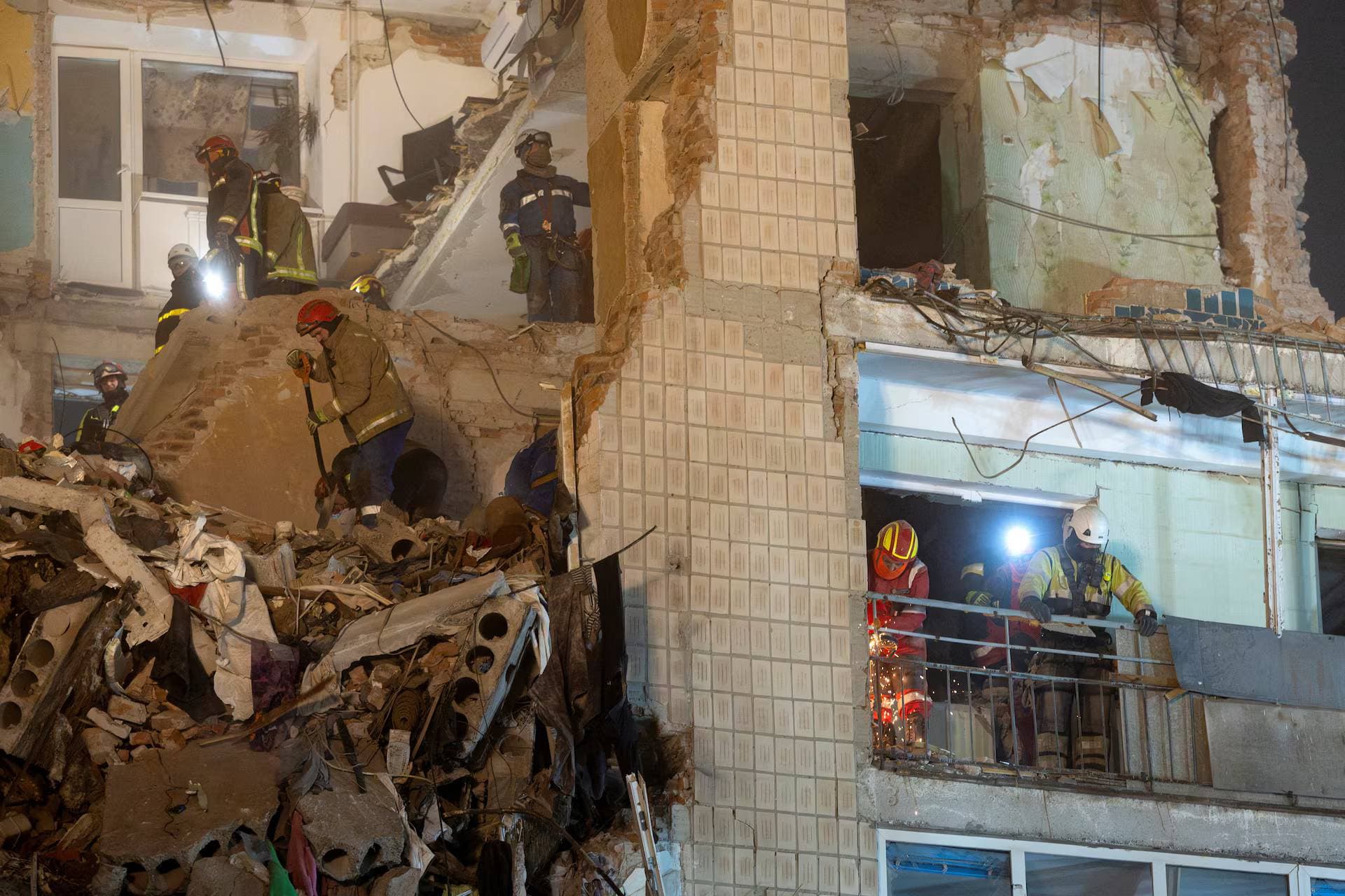 Rescuers clear debris at the site of an apartment building that was hit yesterday by a Russian missile in Ternopil