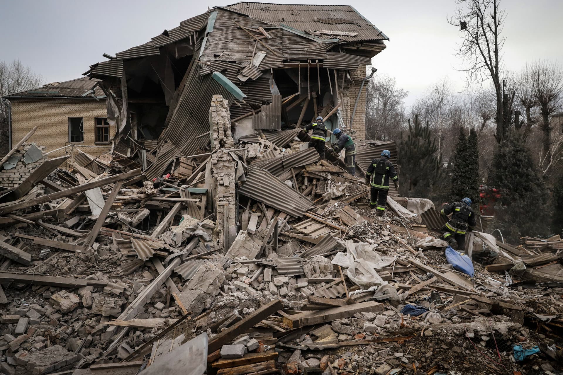 Ukrainian firefighters work at a damaged hospital maternity ward in Vilniansk