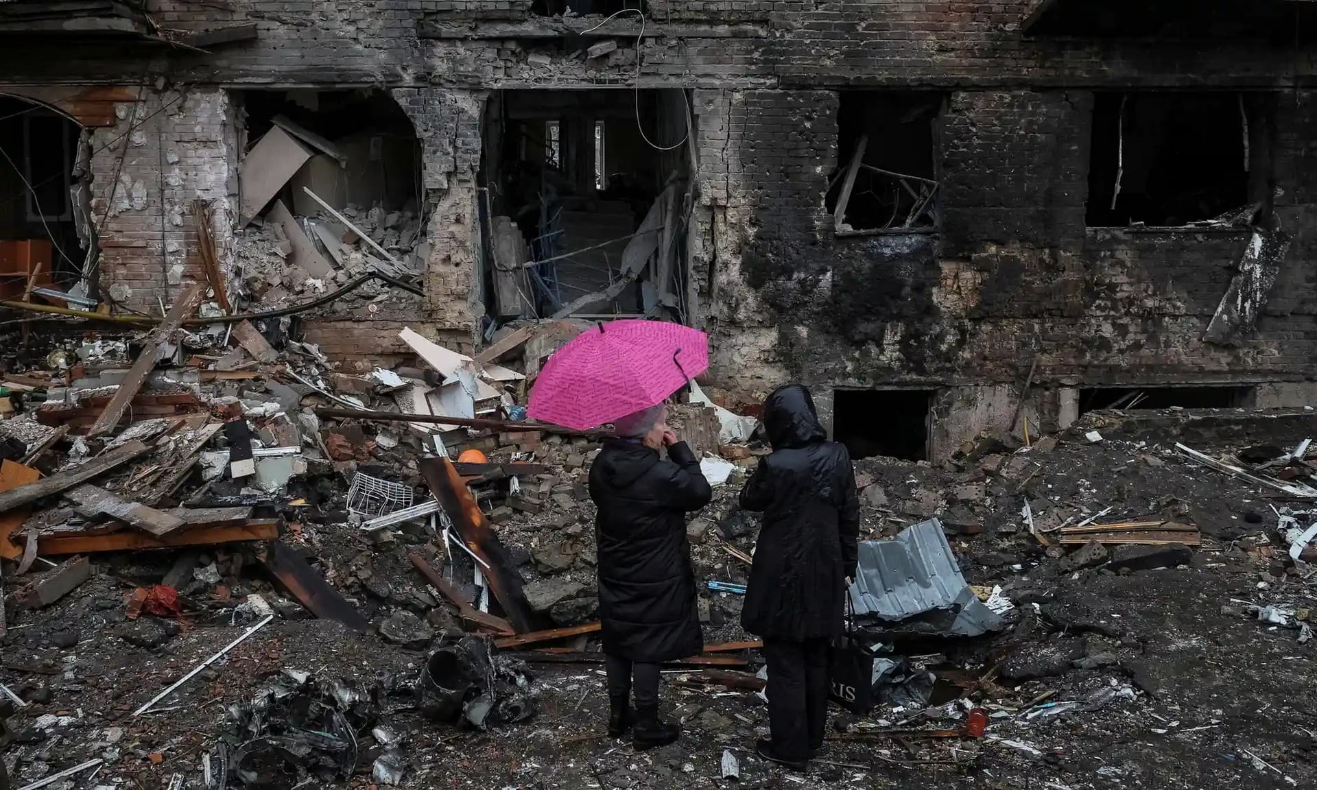 Residents look over the remains of their building, which was destroyed by a Russian missile on Wednesday, in the Kyiv suburb of Vyshhorod.