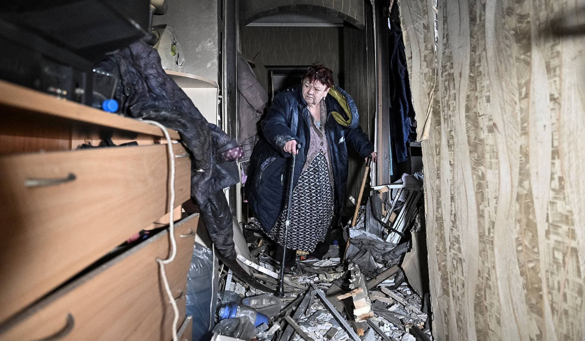 A resident inspects her apartment in a building hit by a Russian drone strike in Zaporizhzhia