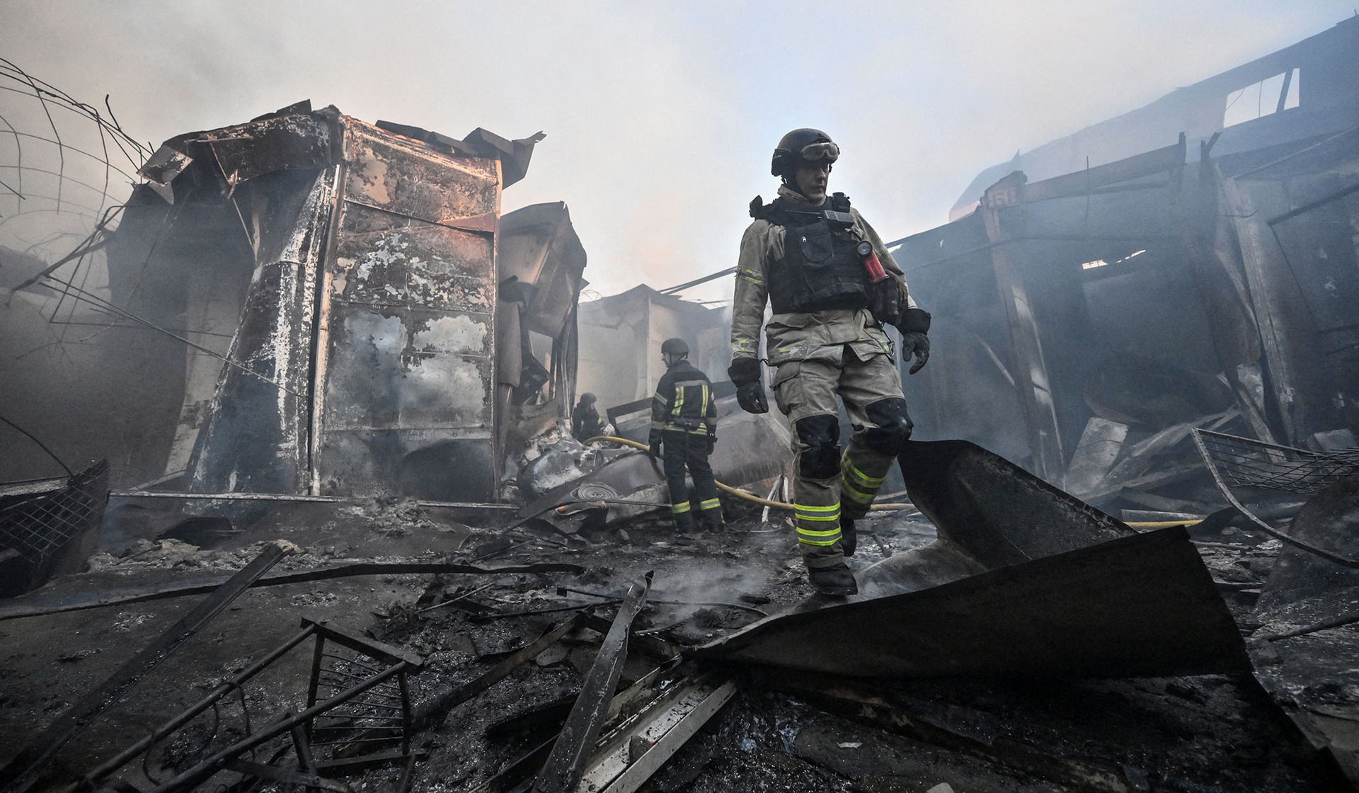 Firefighters work at the site of a damaged market hit during a Russian drone strike in Zaporizhzhia