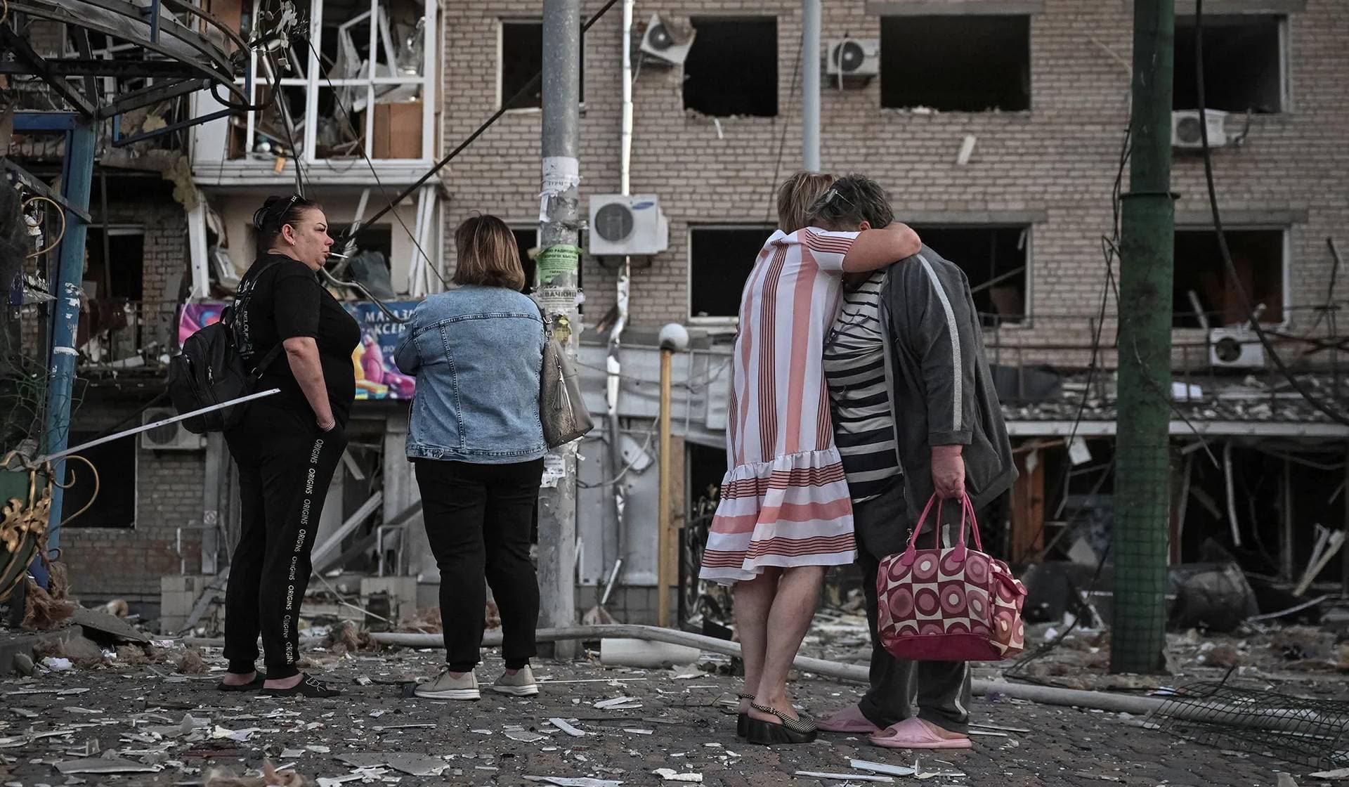 Residents stand at the site of an apartment building hit during a Russian drone and missile strike in Zaporizhzhia