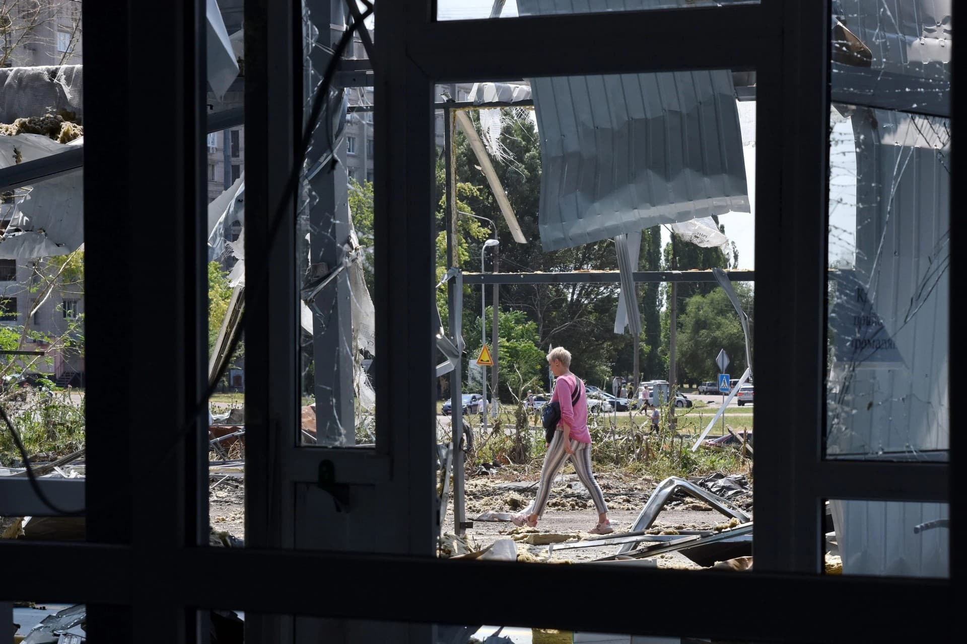 People look at a building destroyed by Russian shelling at night in Zaporizhia