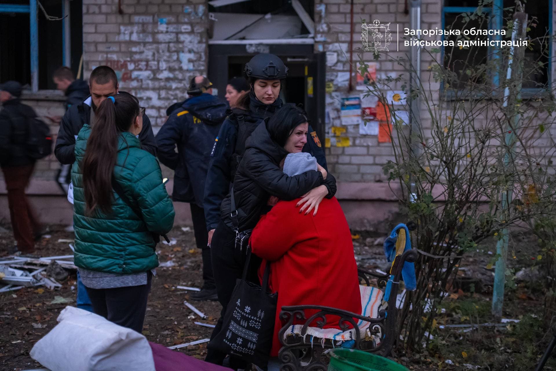 Residents react in front of a dormitory building damaged during an overnight Russian missile and drone strikes in Zaporizhzhia