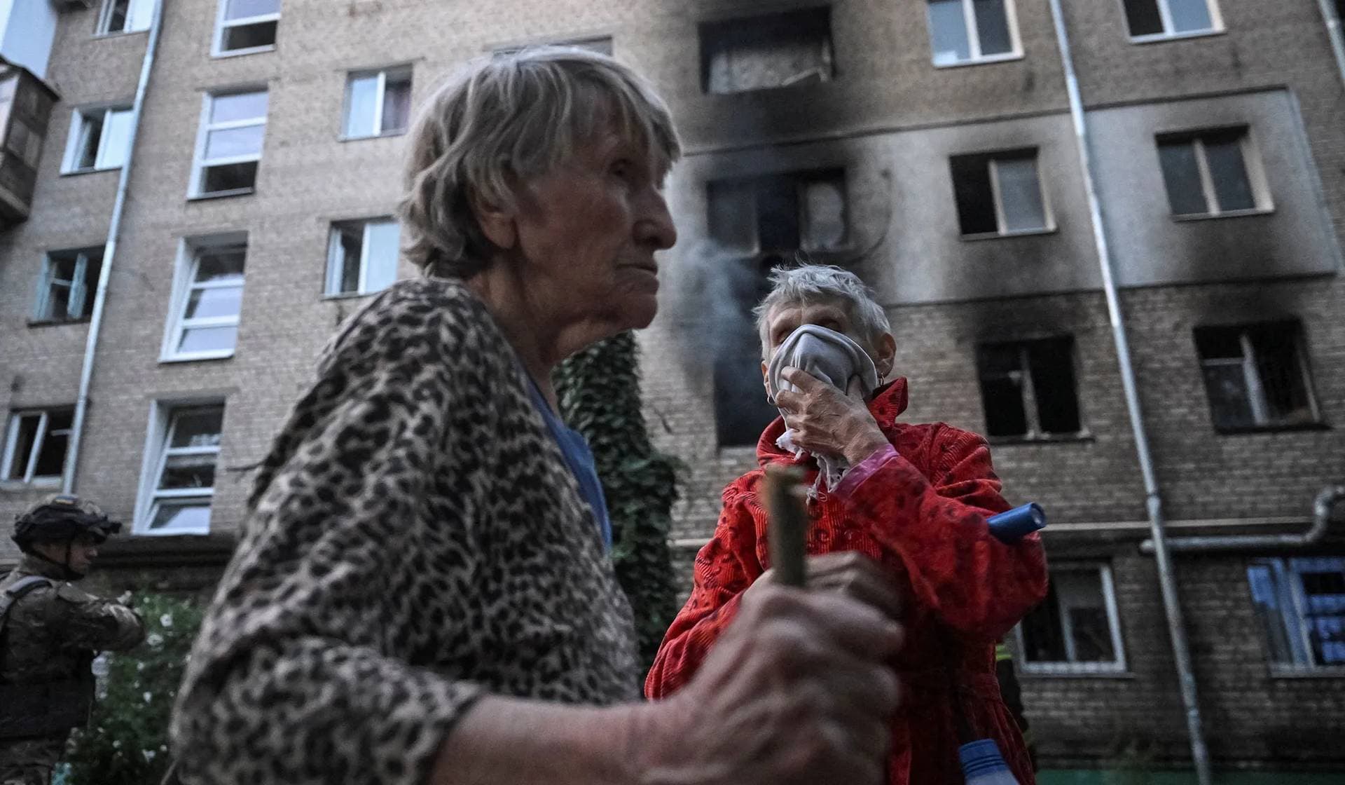 Residents stand near their apartment building, hit during a Russian drone and missile strike in Zaporizhzhia