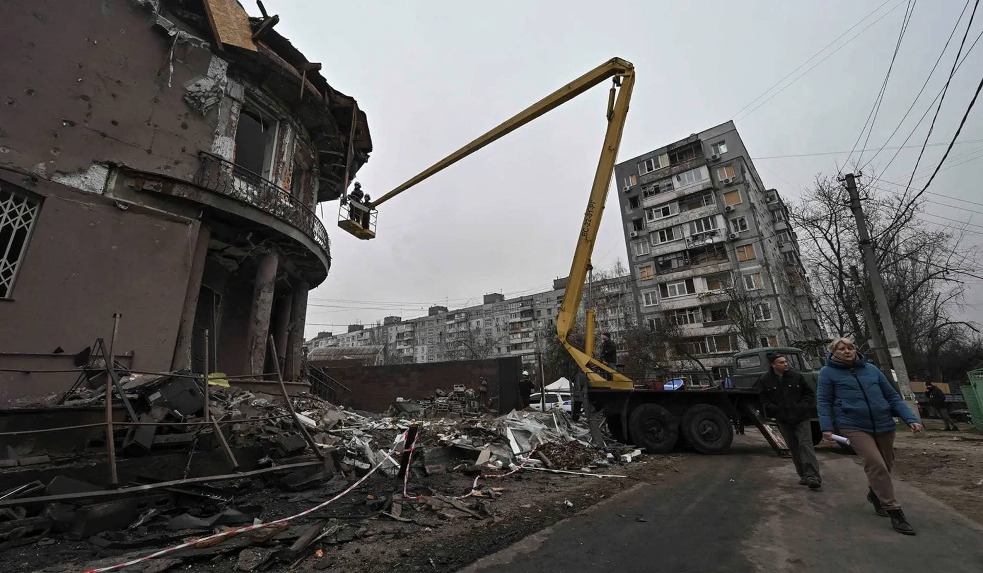 Residents walk past a building damaged by a Russian drone strike in Zaporizhzhia