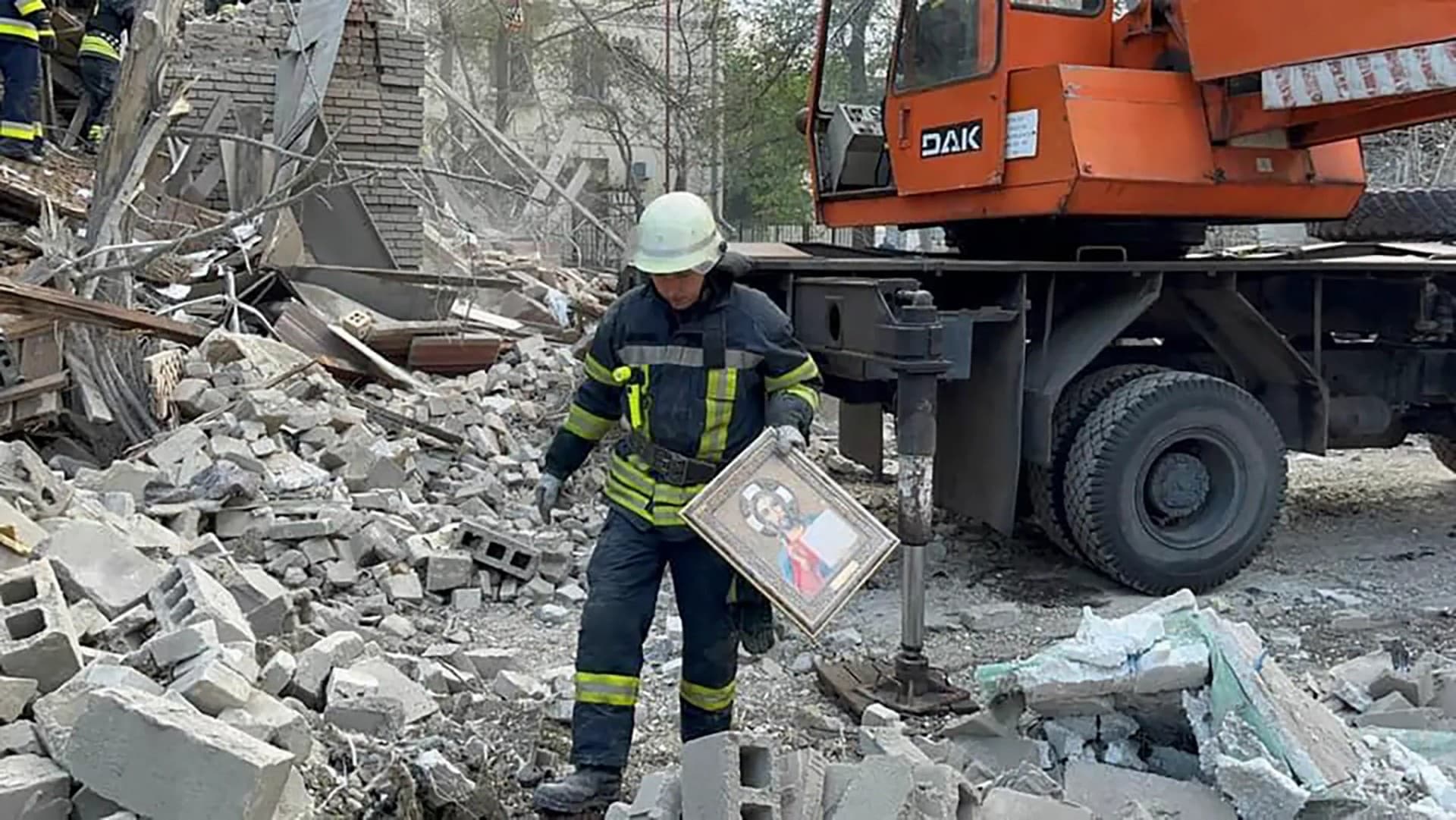 rescuers work on a scene of building damaged by shelling in Zaporizhzhia