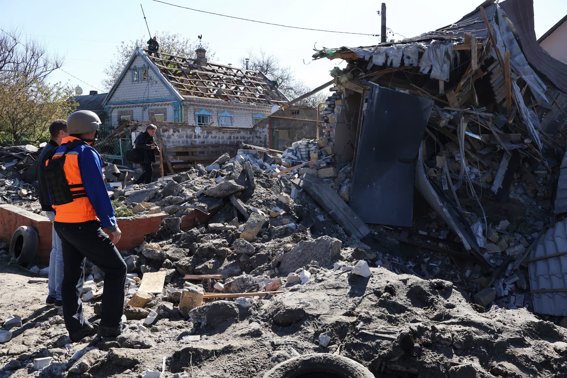 People look at a building destroyed by Russian shelling at night in Zaporizhia