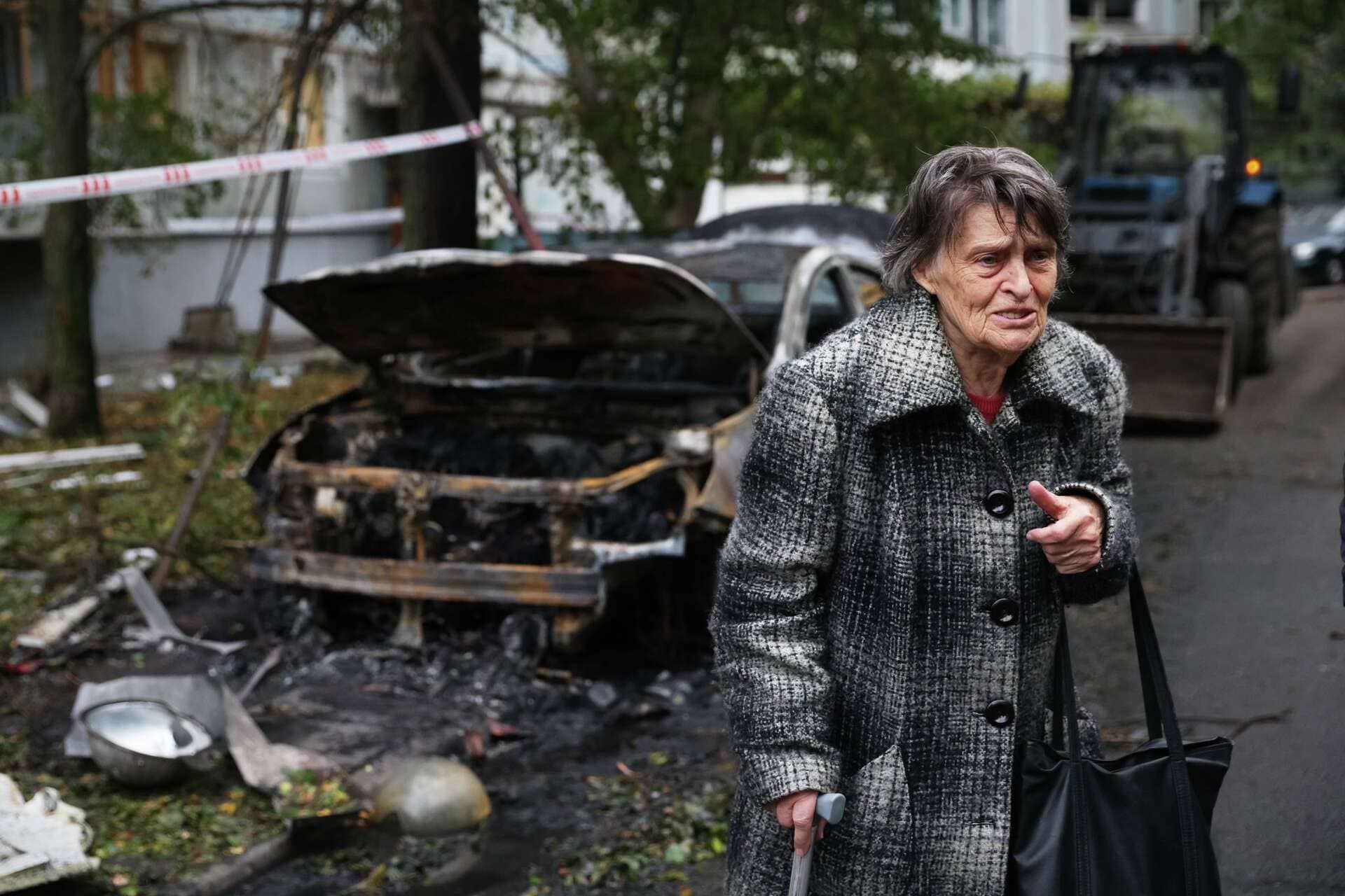 An elderly woman reacts next to the house destroyed by a Russian strike in Zaporizhzhia